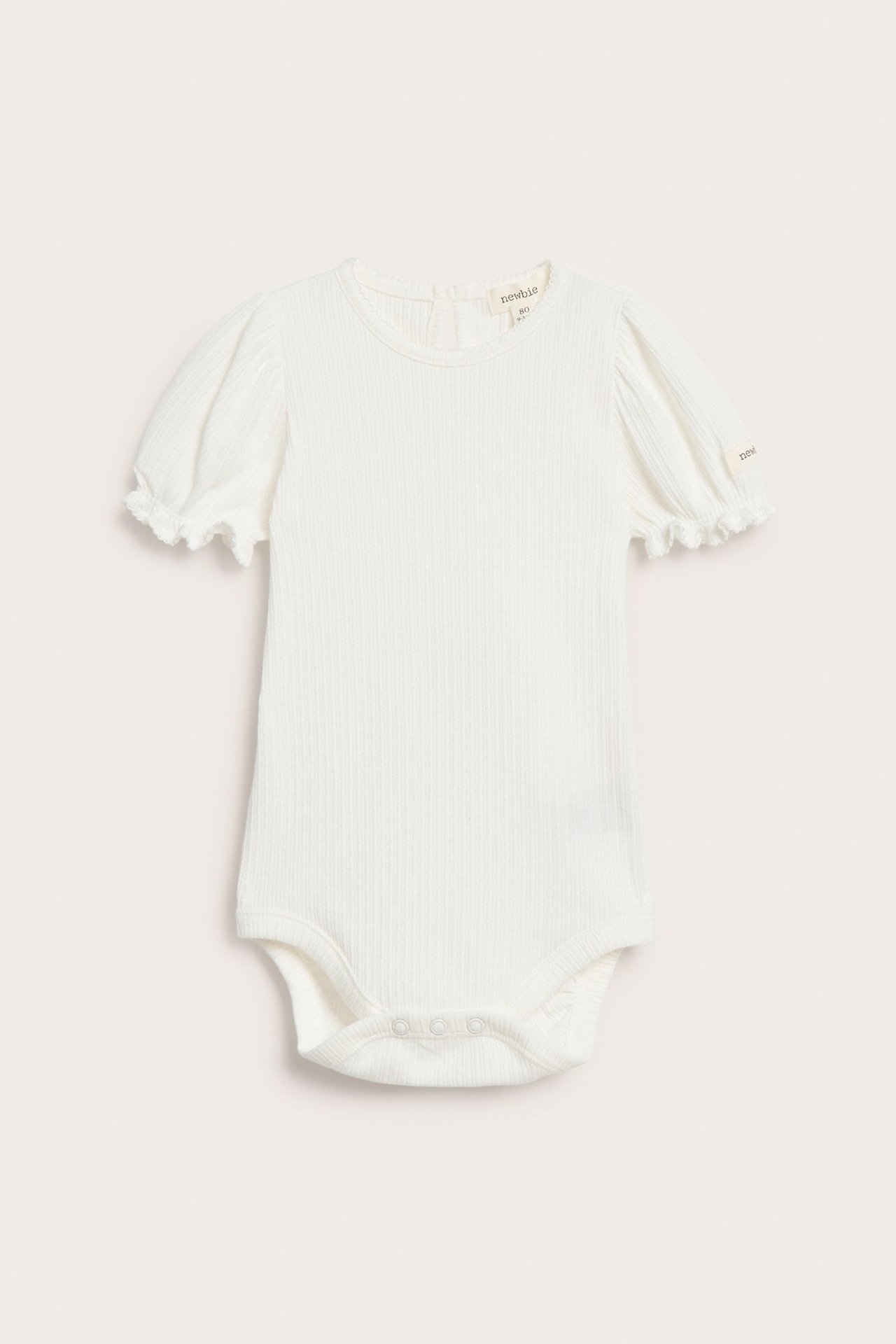 Frontvisning av en offwhite ribbet jersey babybody med korte puffermer og trykknapper.