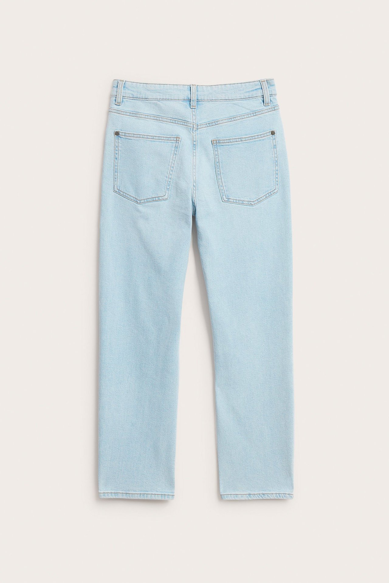 Widok z tyłu jasnoniebieskich luźnych dżinsów z normalnym stanem i dwiema tylnymi kieszeniami.