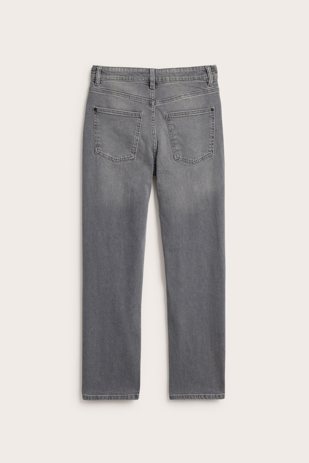 Tylny widok jasnoszarych, luźnych dżinsów dziecięcych z podwyższonym stanem i dwiema tylnymi kieszeniami.