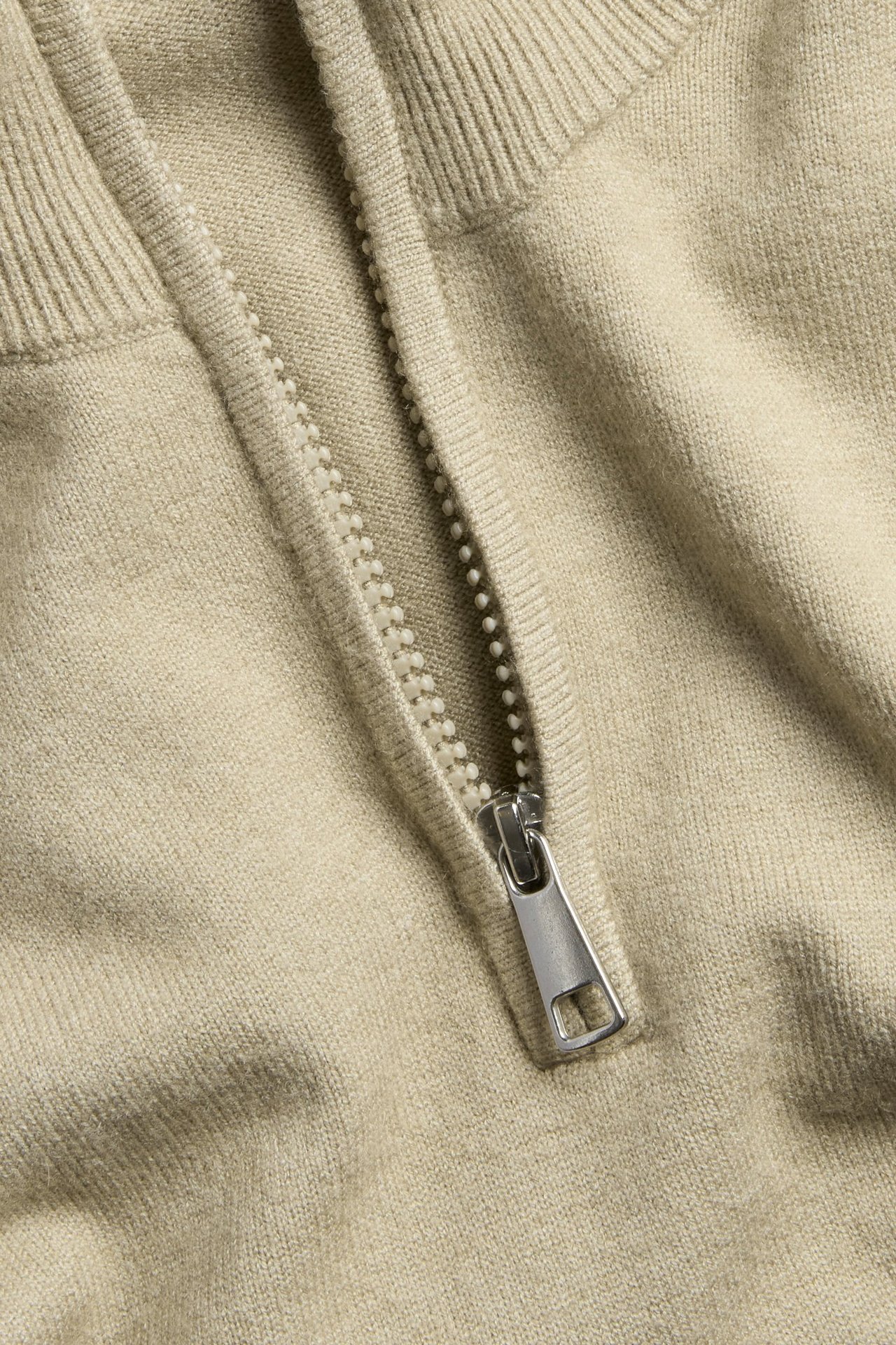 Beige neulottu collegetakki vetoketjulla, mosaiikkikuvio, lähikuva.