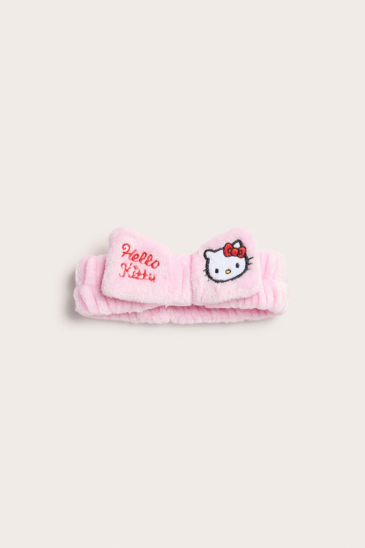 Forfra: Rosa mykt Hello Kitty hårbånd i polyester med brodert sløyfe.