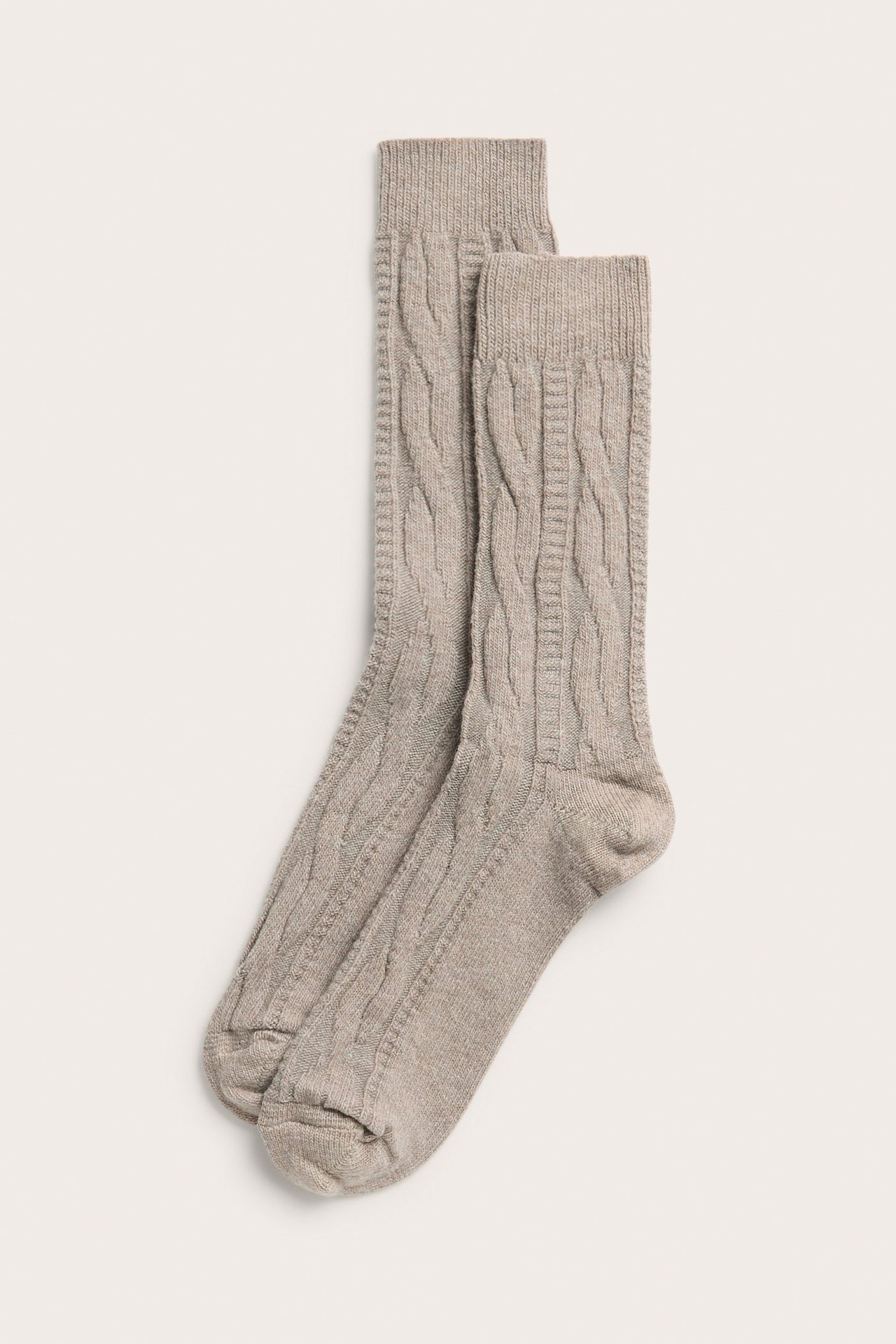 Widok z góry na parę jasnobrązowych melanżowych skarpet z mieszanki wełny ze splotem warkoczowym.