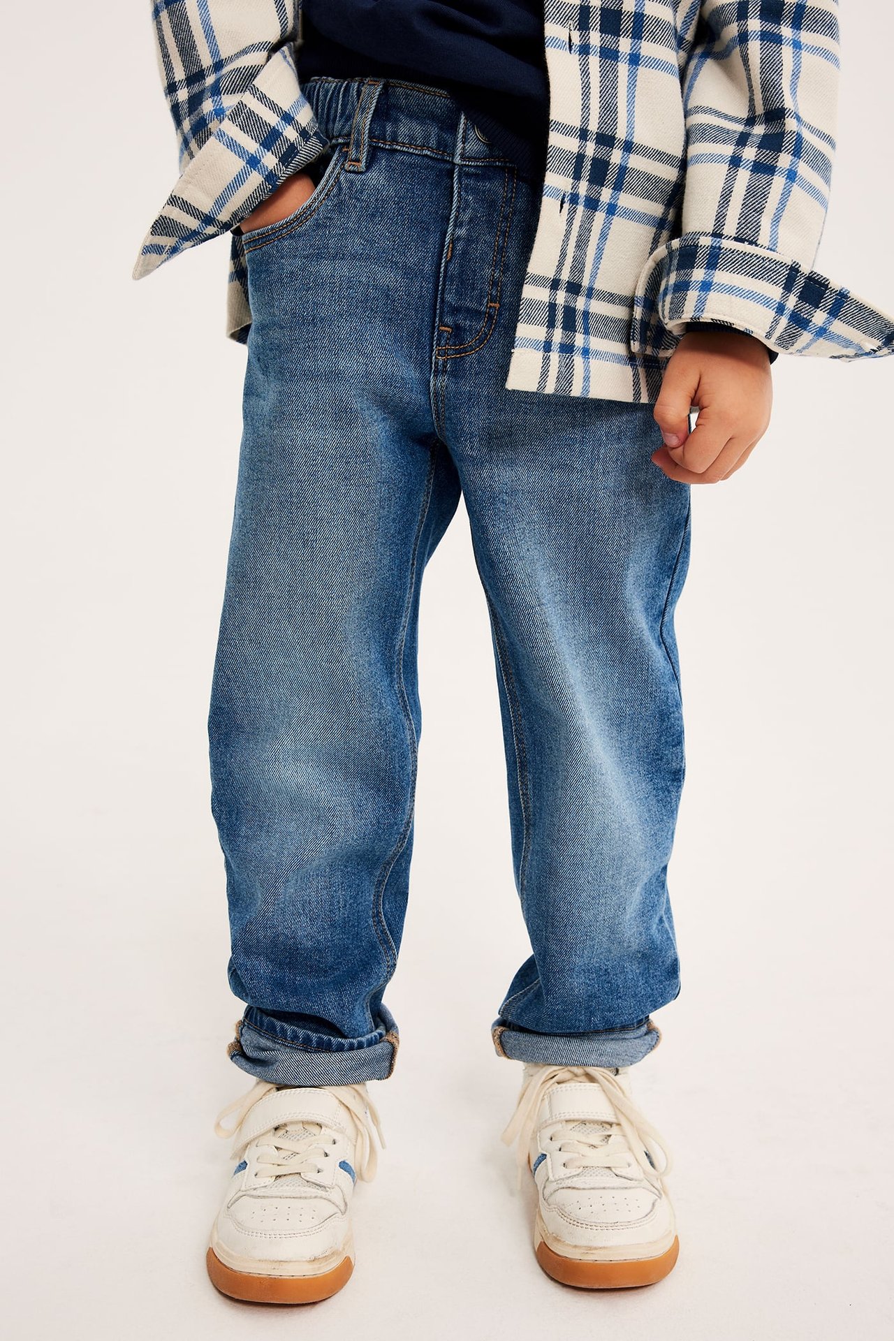Frontutsikt: Barn bruker blå jeans, rutete skjorte, marineblå t-skjorte, hvite joggesko.