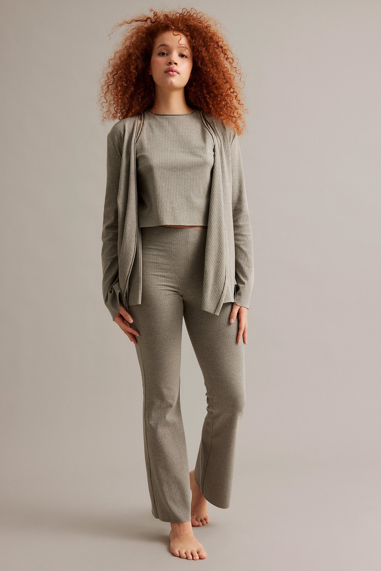 Edestä: nainen yllään melange-ruskeat ribatut bootcut-housut, yhteensopiva crop-toppi ja avoin neuletakki.