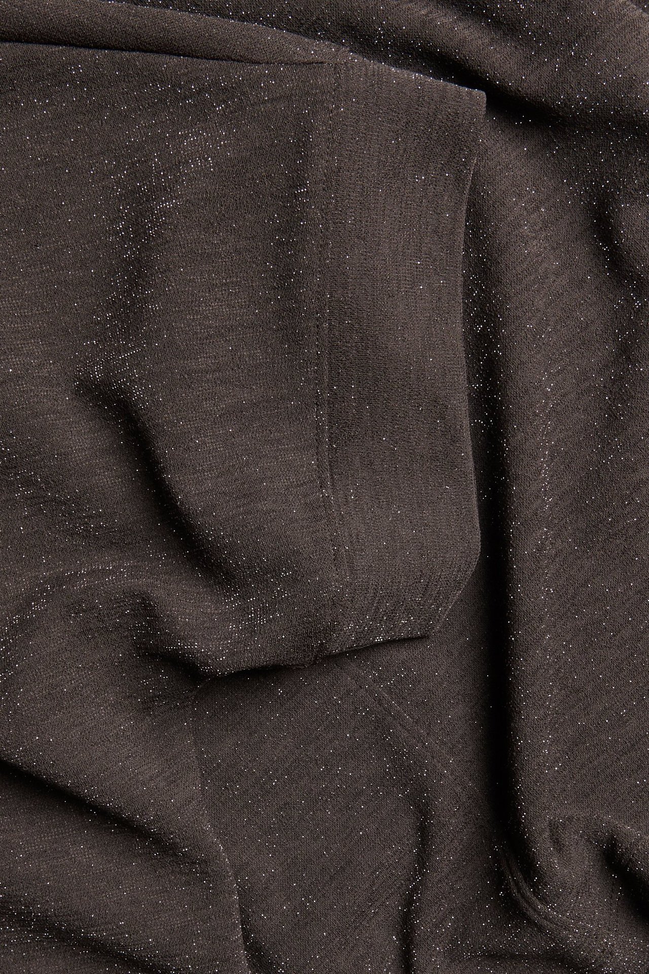 Zbliżenie na ciemnobrązowy, błyszczący materiał lurex na top z krótkim rękawem.