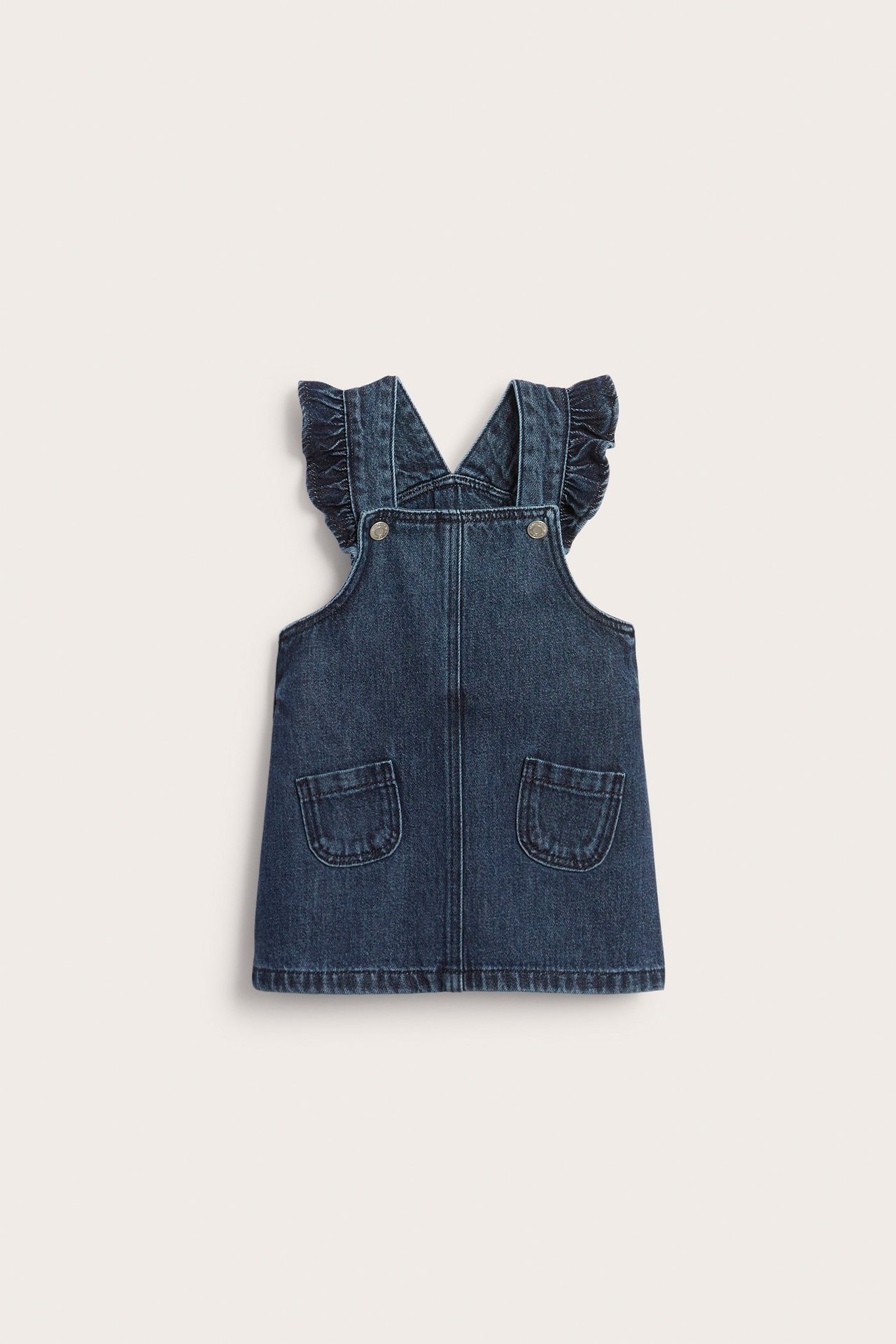 Edestä kuvattu vauvan farkkumekko, jossa on röyhelöt olkapäillä, etutaskut ja painonapit.