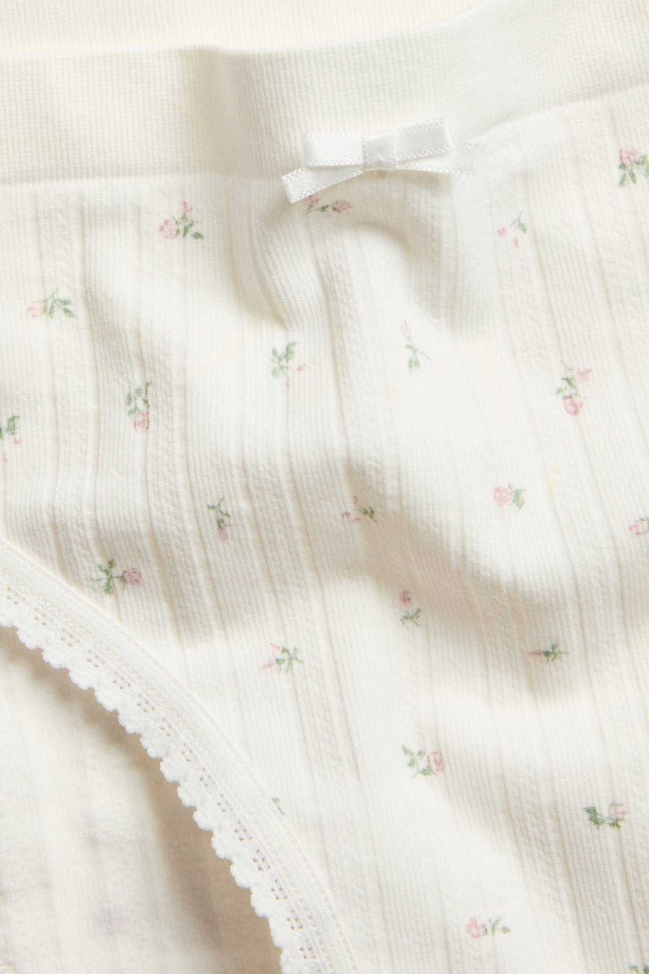 Hvit seamless briefs med mønstret pointelle, vanlig midje, liten sløyfe foran.