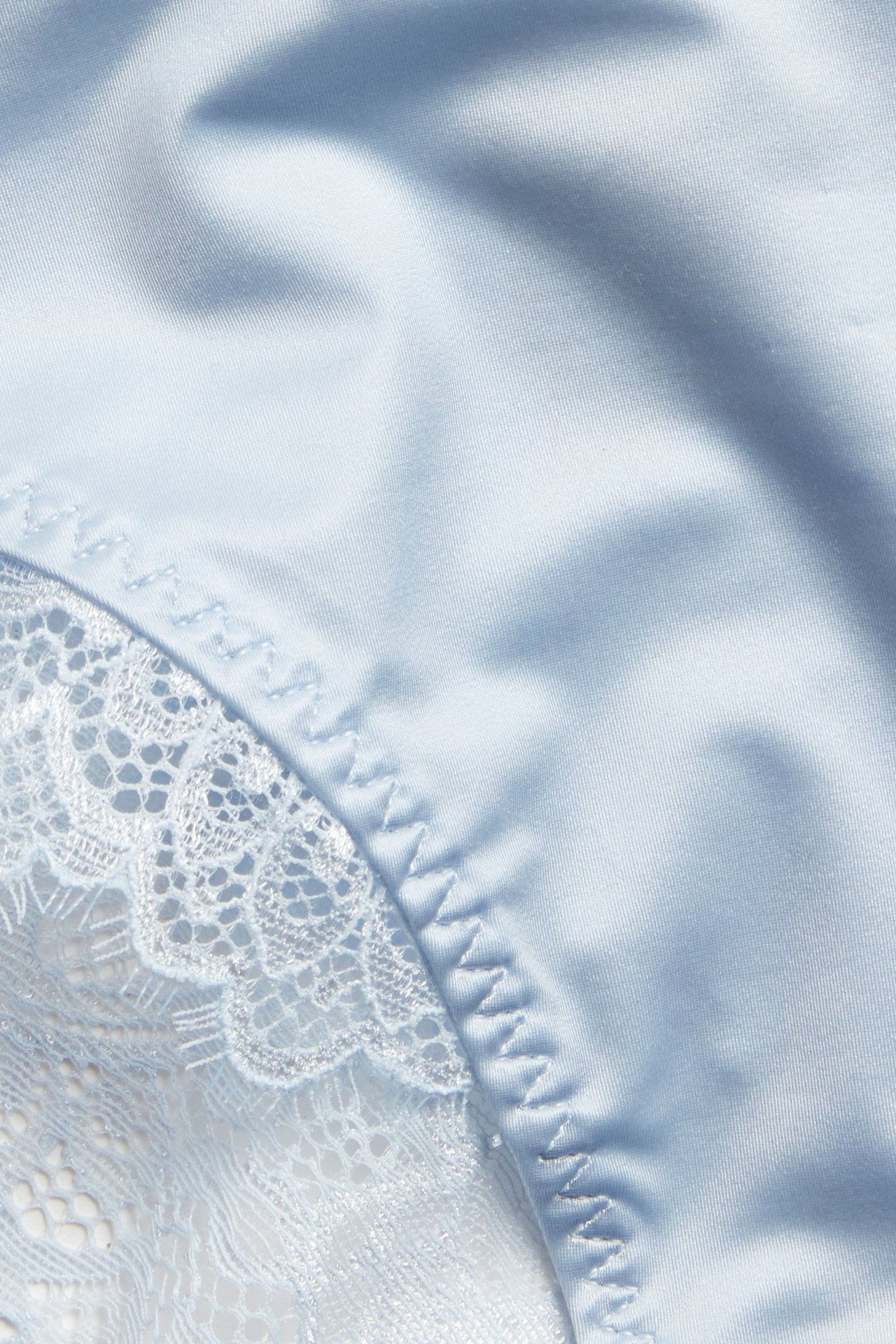 Zbliżenie na niebieskie majtki midi z recyklingowanej mikrofibry z białymi koronkowymi detalami.