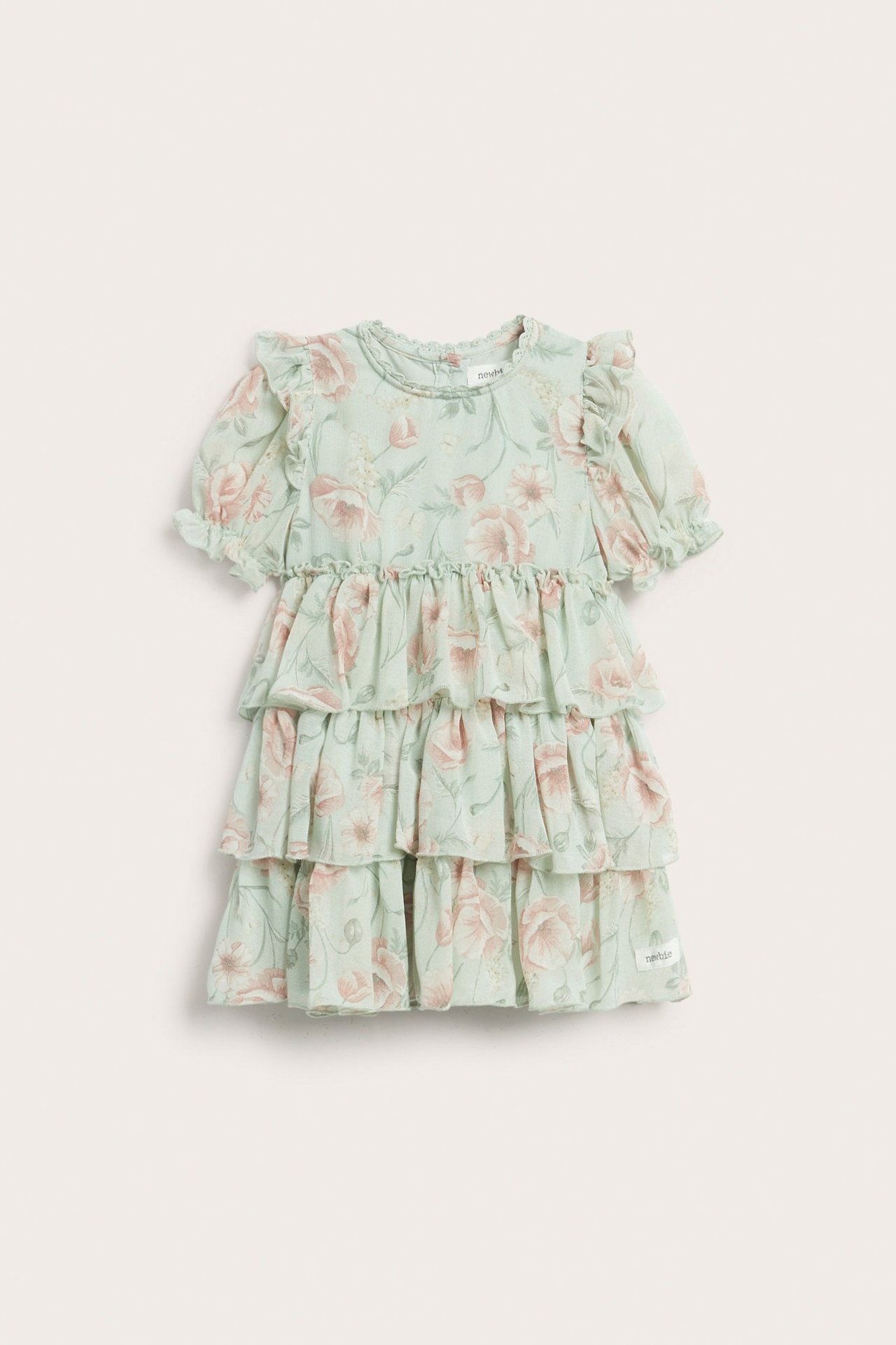 Widok z przodu: zielona szyfonowa sukienka dziecięca w kwiaty, z falbankami i bufiastymi rękawami.