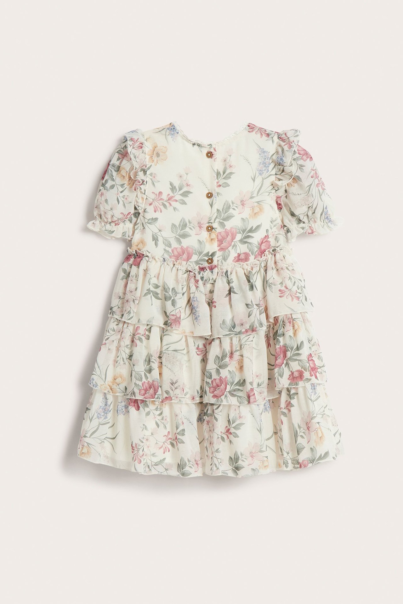 Bakfra, offwhite blomstret chiffonkjole for barn med volanger, puffermer og knapper i ryggen.
