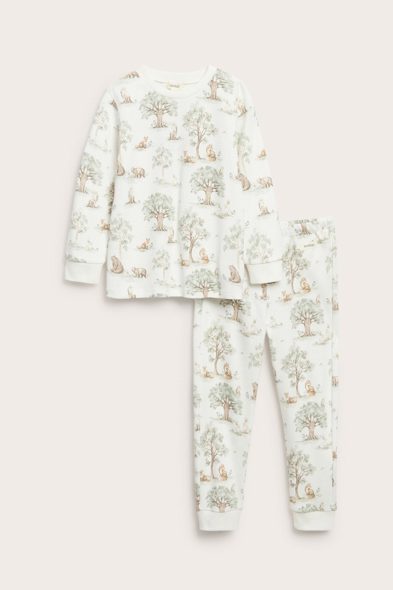 Framifrån: Pyjamas för barn i offwhite bomull med skog- och djurmönster.