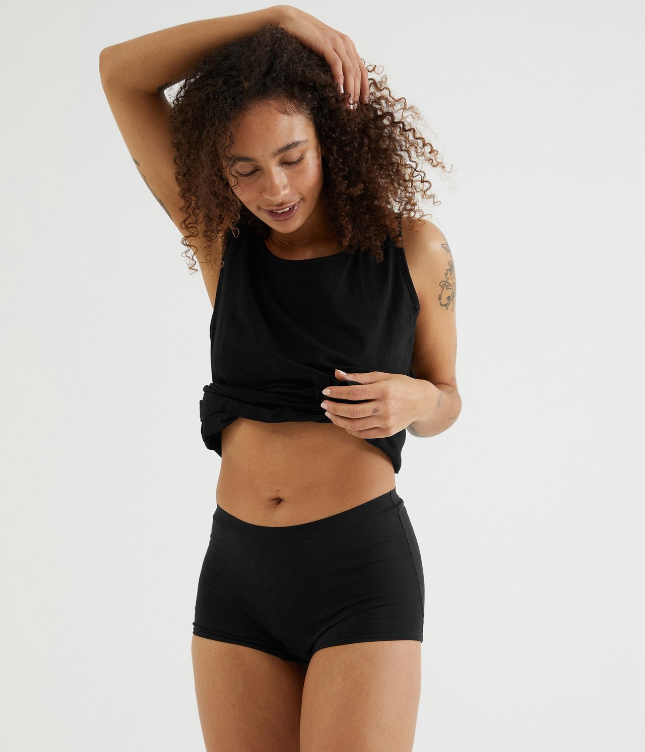 Widok z przodu kobiety w czarnych bawełnianych bokserkach i czarnym podkoszulku.