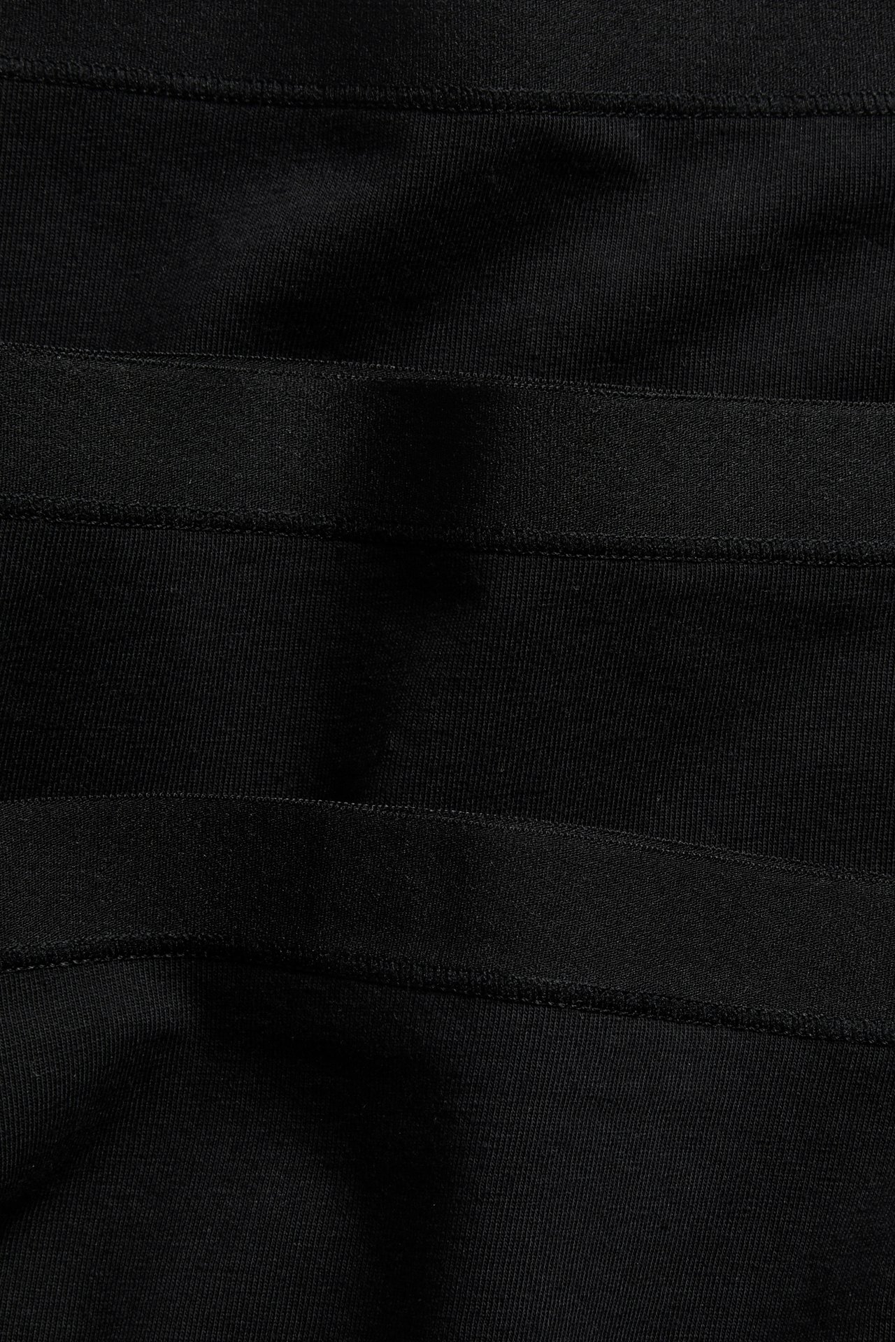 Lähikuva taitetuista mustista puuvillabokserihousuista, joissa näkyy joustavat vyötärönauhat.