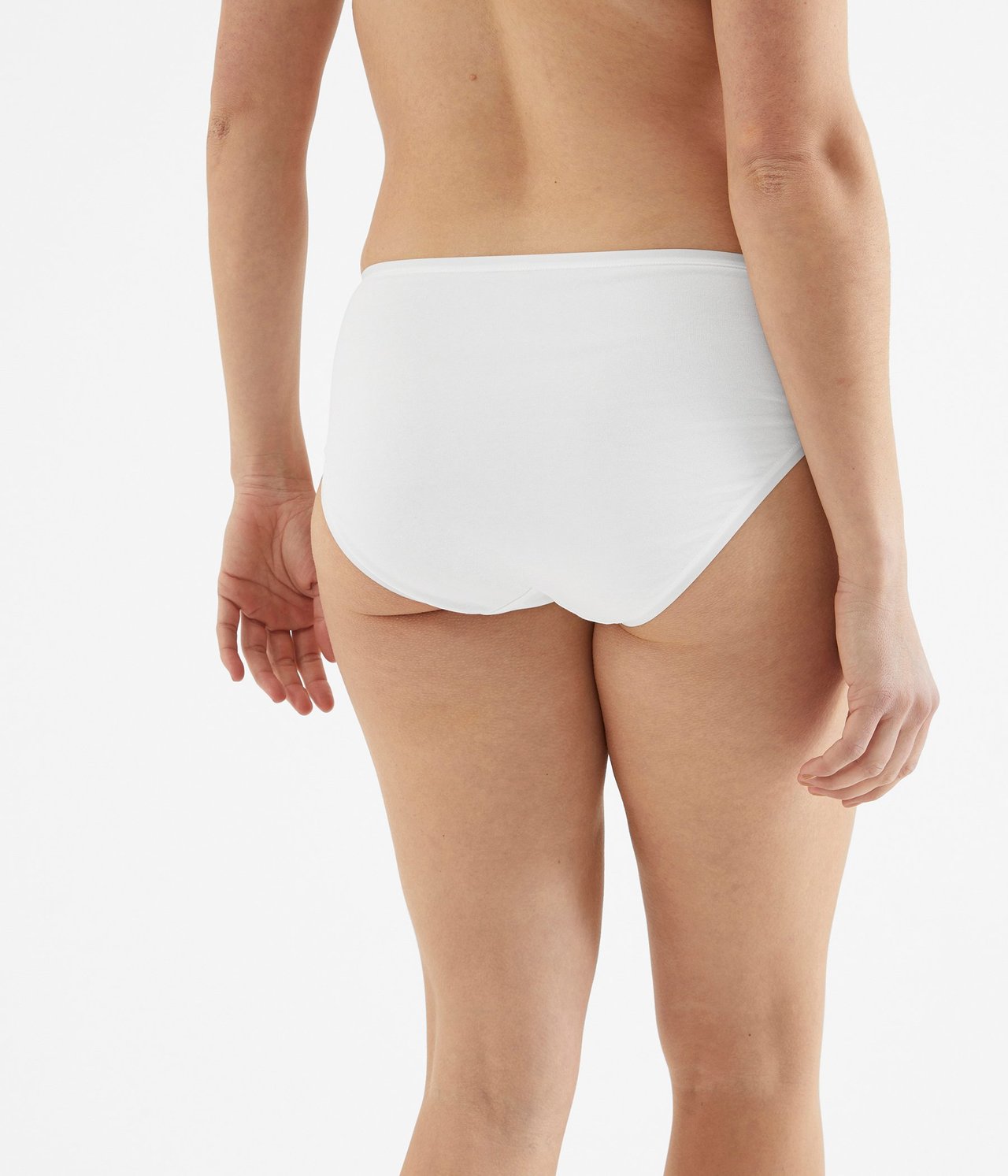 Bakifrån, kvinna i enfärgade vita bomullstrosor.