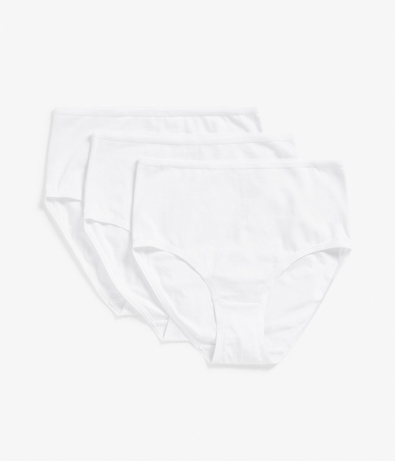 Widok z góry na trzy białe bawełniane majtki z wysokim stanem, ułożone lekko na sobie.