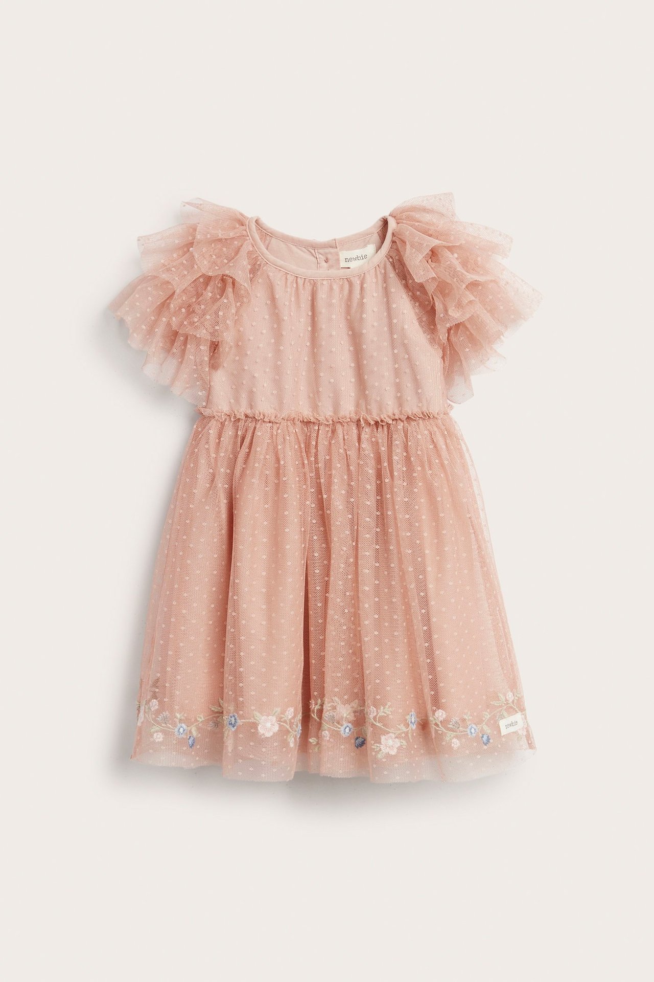 Frontvisning av en rosa prikket meshkjole for barn med volangermer og brodert blomsterkant.