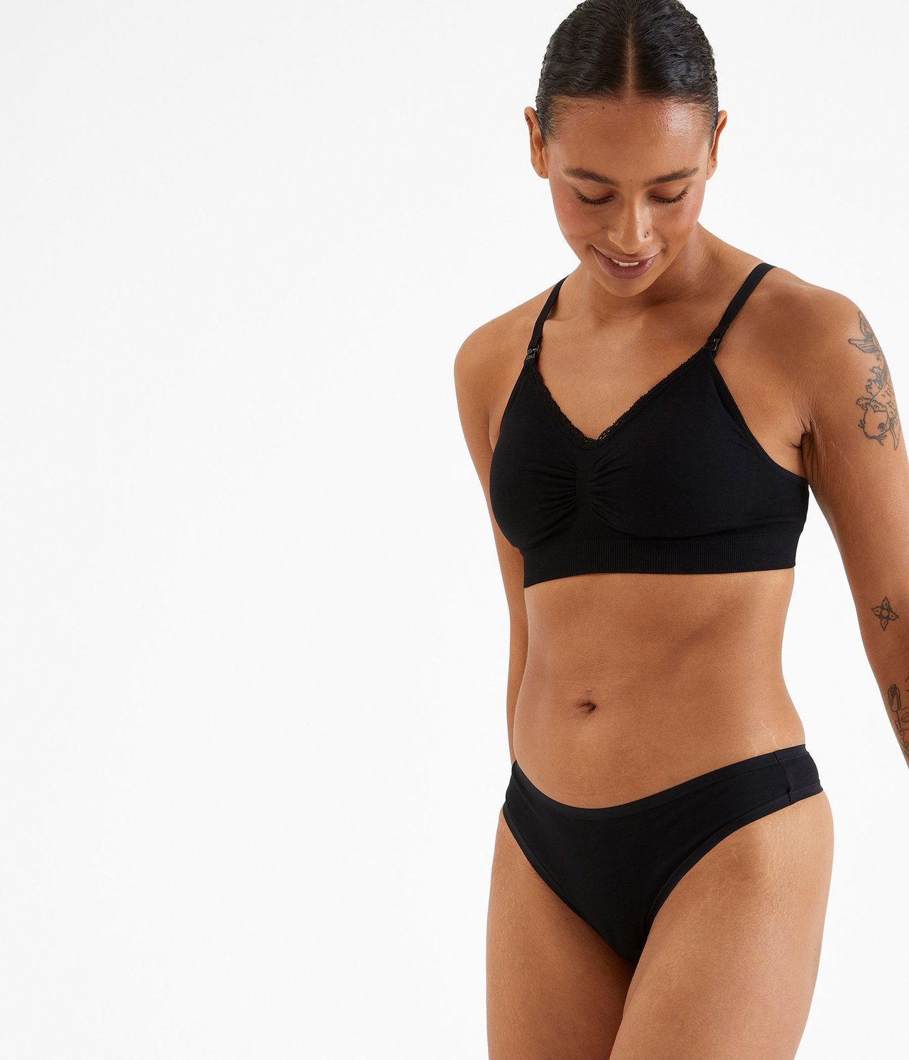 Widok z przodu kobiety w czarnych bawełnianych stringach i czarnym prążkowanym miękkim biustonoszu.