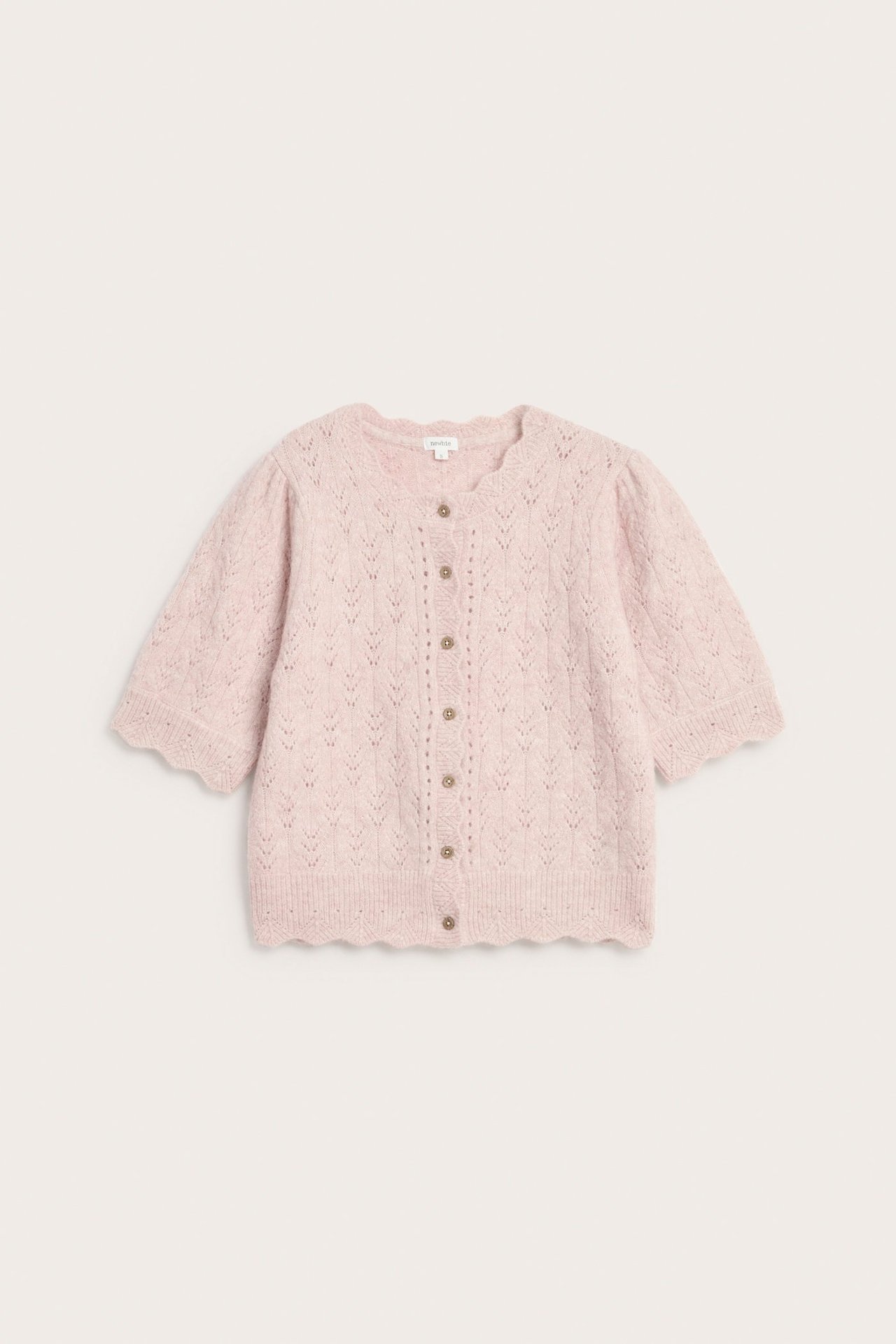 Widok z przodu różowego dzianinowego swetra damskiego z mieszanki wełny, we wzory i falbankowe brzegi.