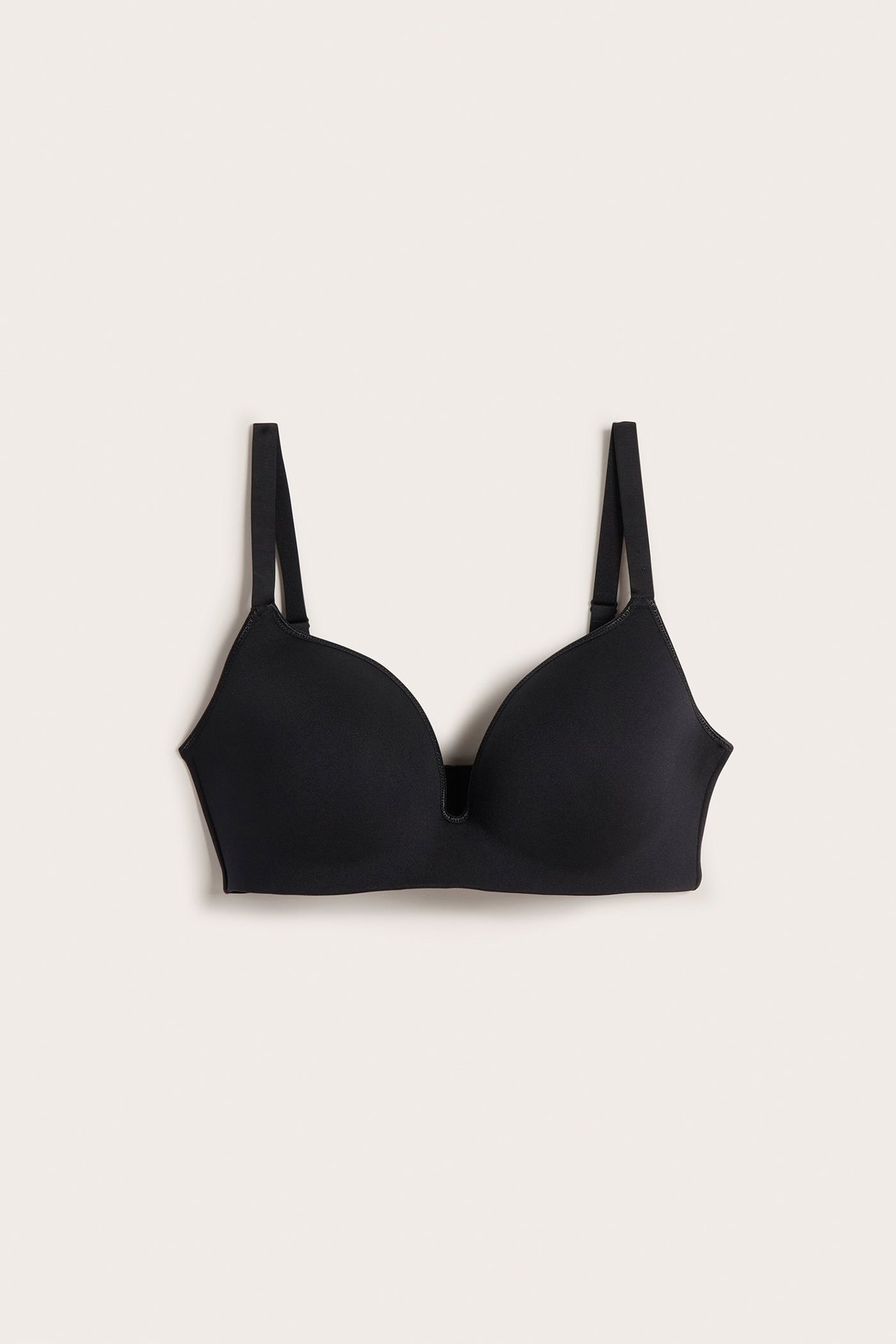 Edestä musta saumaton rintaliivi syvällä V-pääntiellä ja säädettävillä olkaimilla.