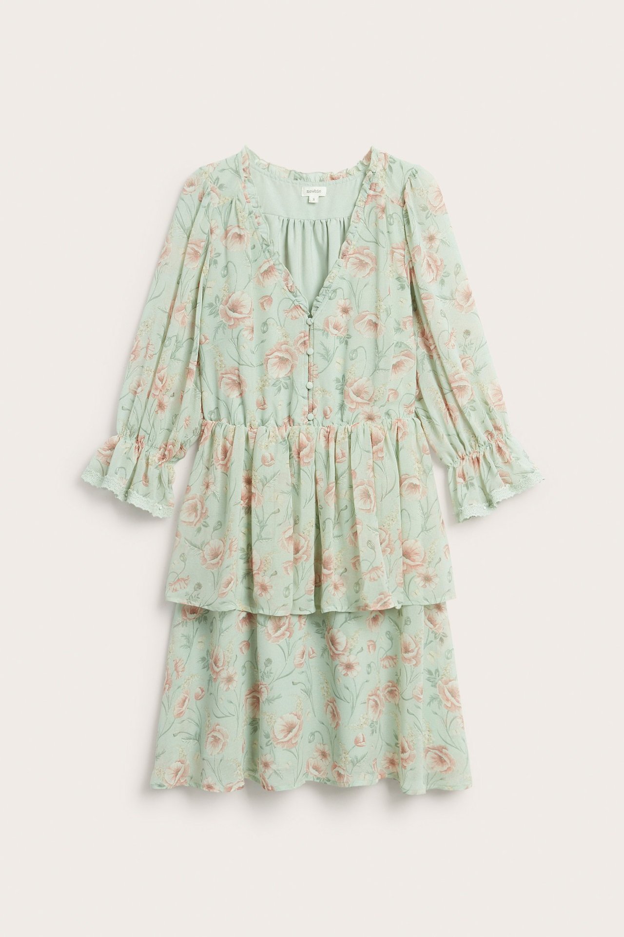 Framifrån, ljusgrön blommig chiffongklänning med volanger, V-ringning och klädda knappar.