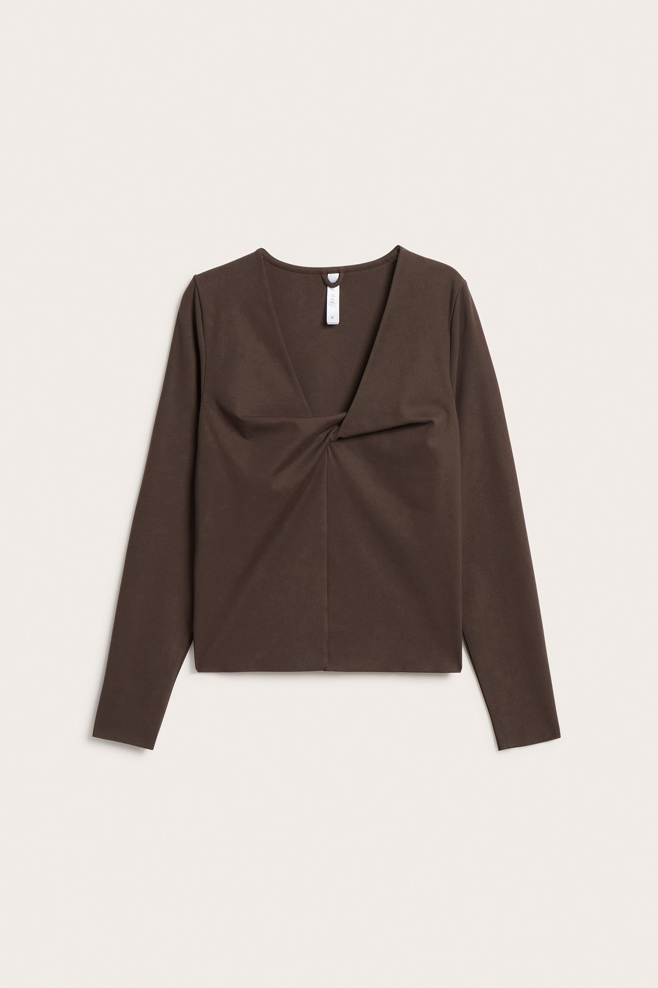 Edestä näkymä ruskeasta pitkähihaisesta trikoisesta treenipaidasta, jossa V-pääntie ja solmuyksityiskohta edessä.