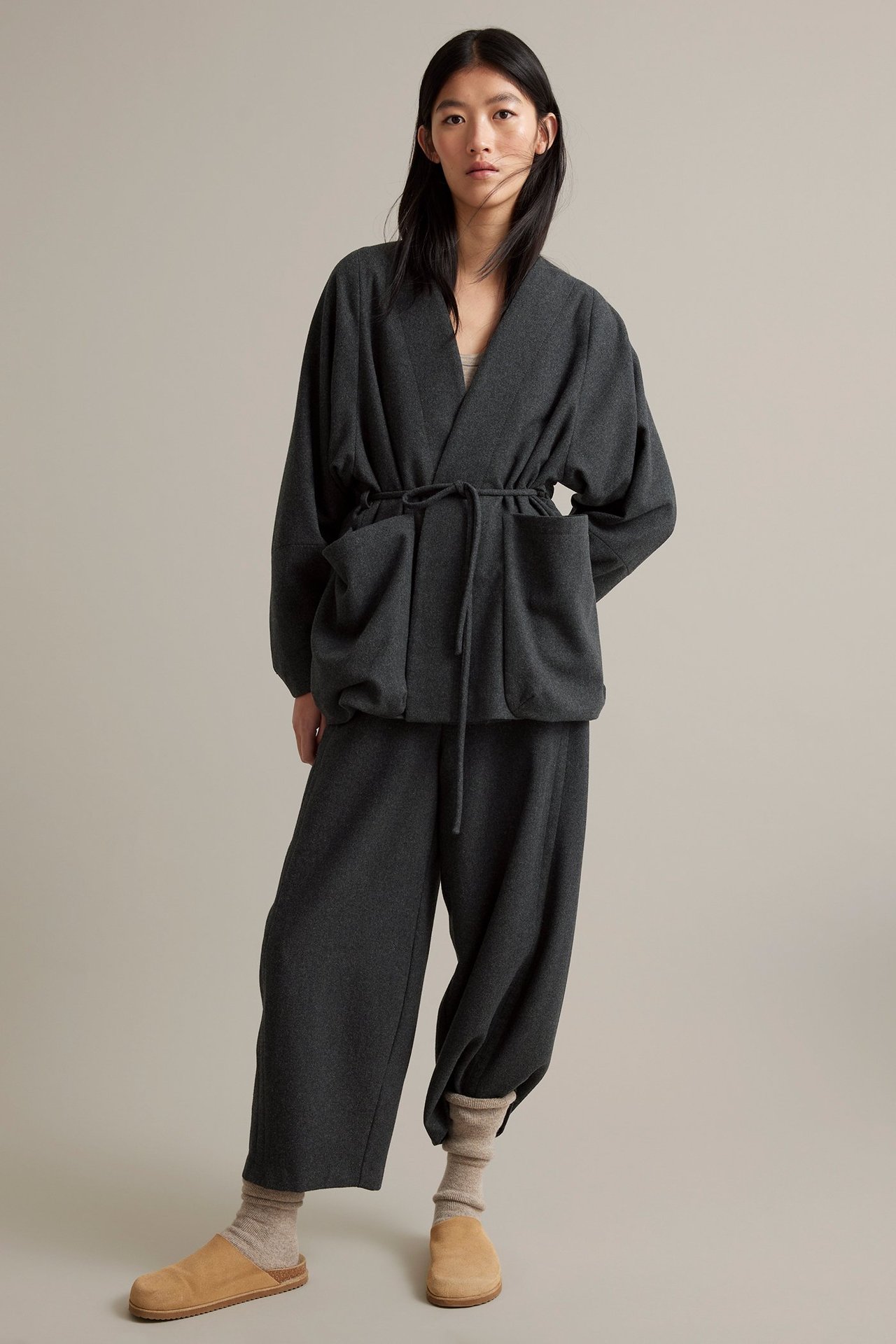 Nainen tummanharmaa villasekoitekka, vyöllä, vuorellinen, ei liepeitä, yhdensivuiset housut.