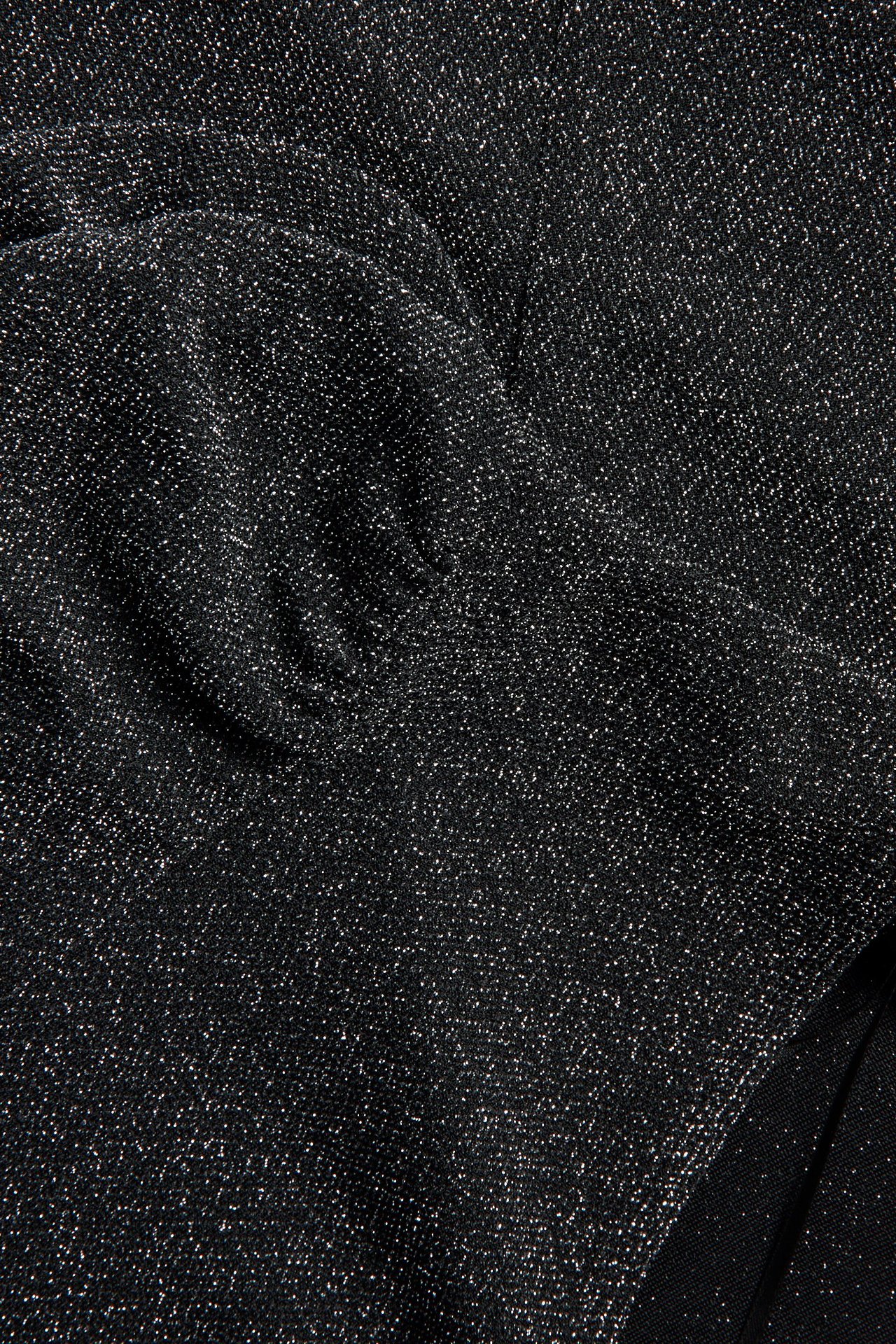 Zbliżenie czarnej, krótkiej sukienki z dzianiny z lureksu i brokatem.