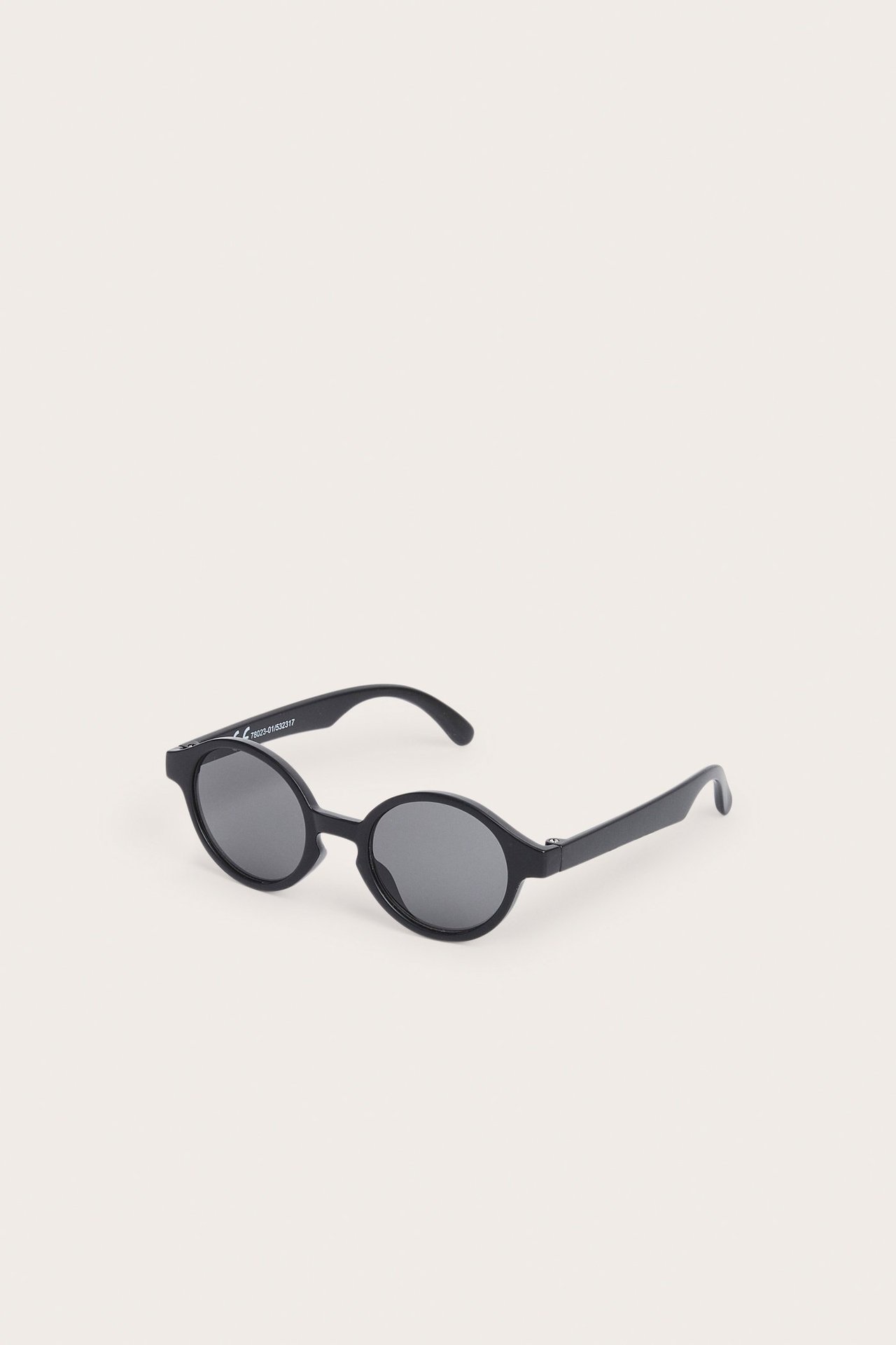 Lähikuva mustista soikeista muovisista aurinkolaseista vauvalle tummilla linsseillä.