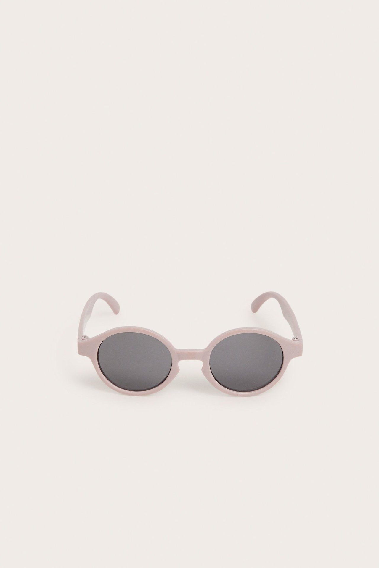 Widok z przodu różowych owalnych okularów przeciwsłonecznych dla niemowląt z ciemnymi soczewkami.