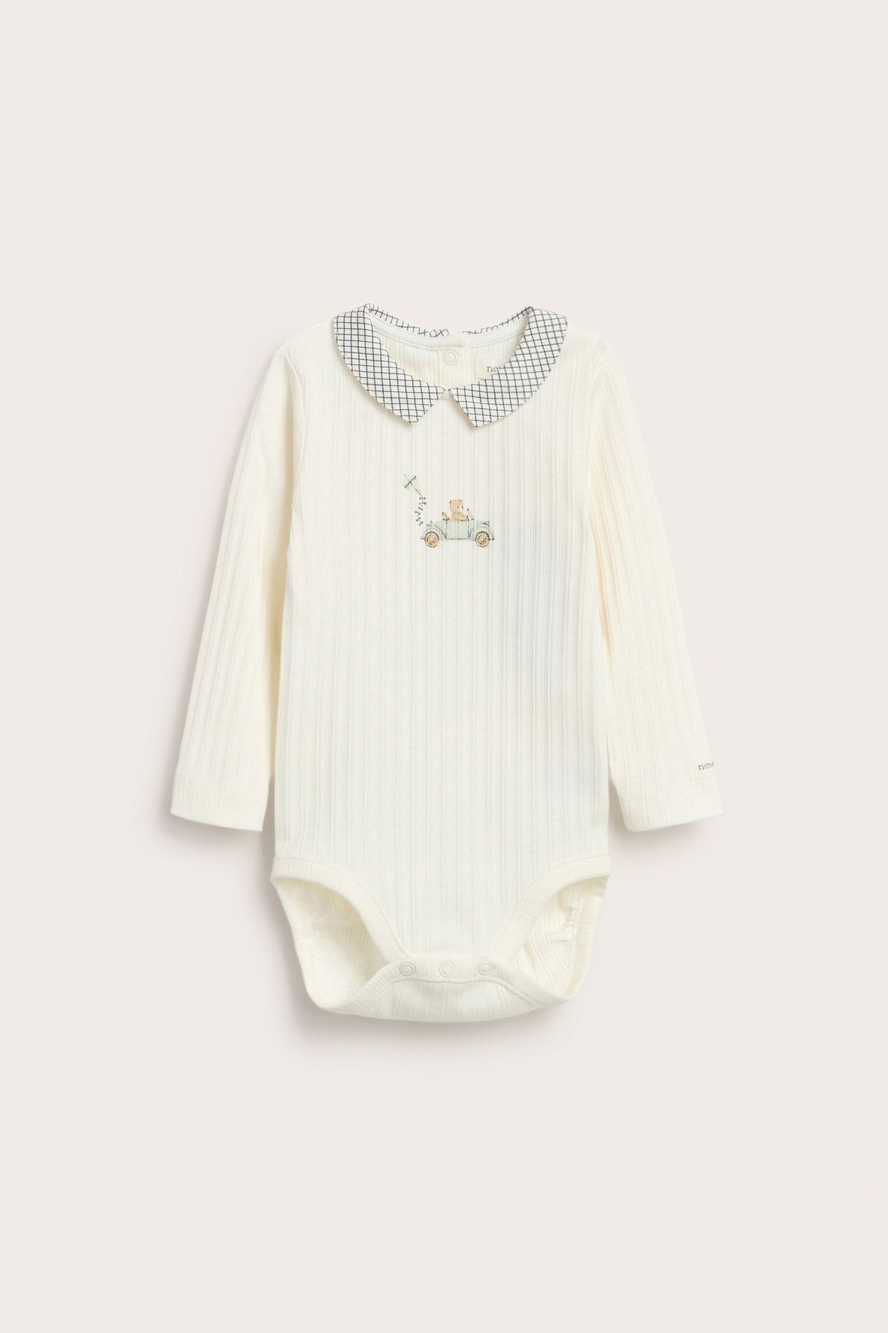 Hvit ribbekropp med krage, trykk på forsiden, knapper bak og i mellom for baby gutt.