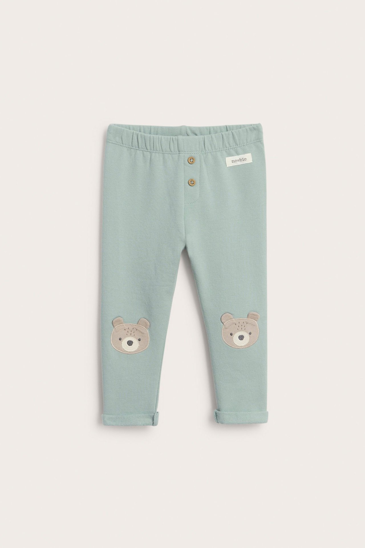 Vaaleanvihreät fleecelegginsit lapsille, napit, broderi ja kääntyvät lahkeet, karhu-aihe.