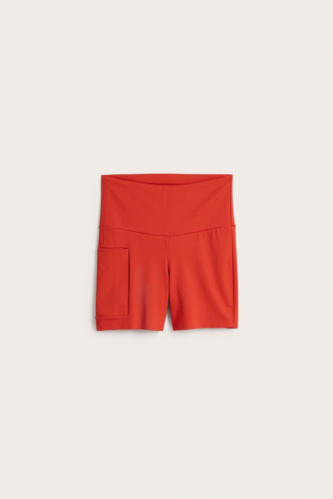 Widok z przodu: Czerwone szorty kolarskie z wysokim stanem, z dzianiny, z kieszenią na telefon.