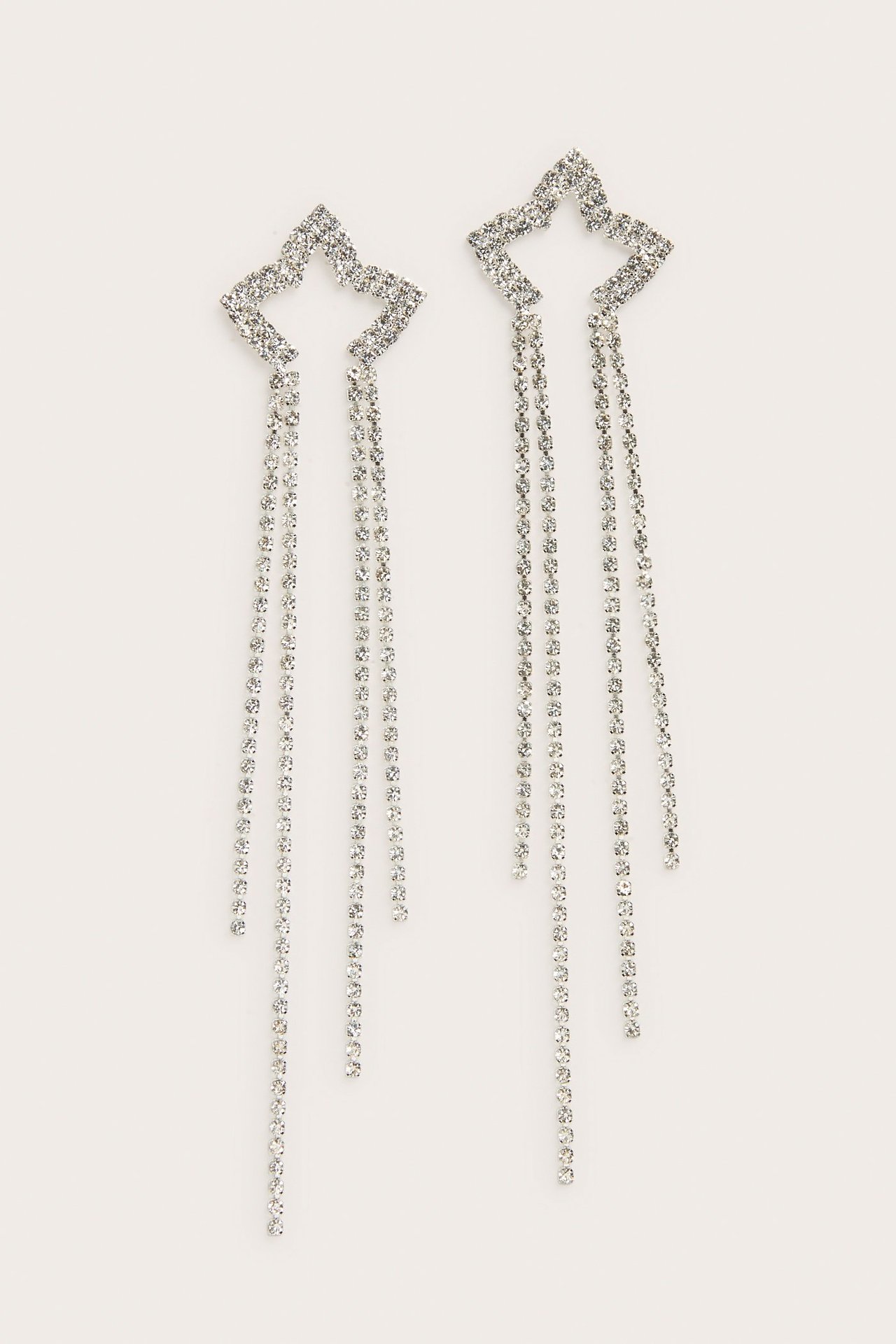 Et par lange sølvfargede stjerneøredobber med strass og dinglende kjeder.