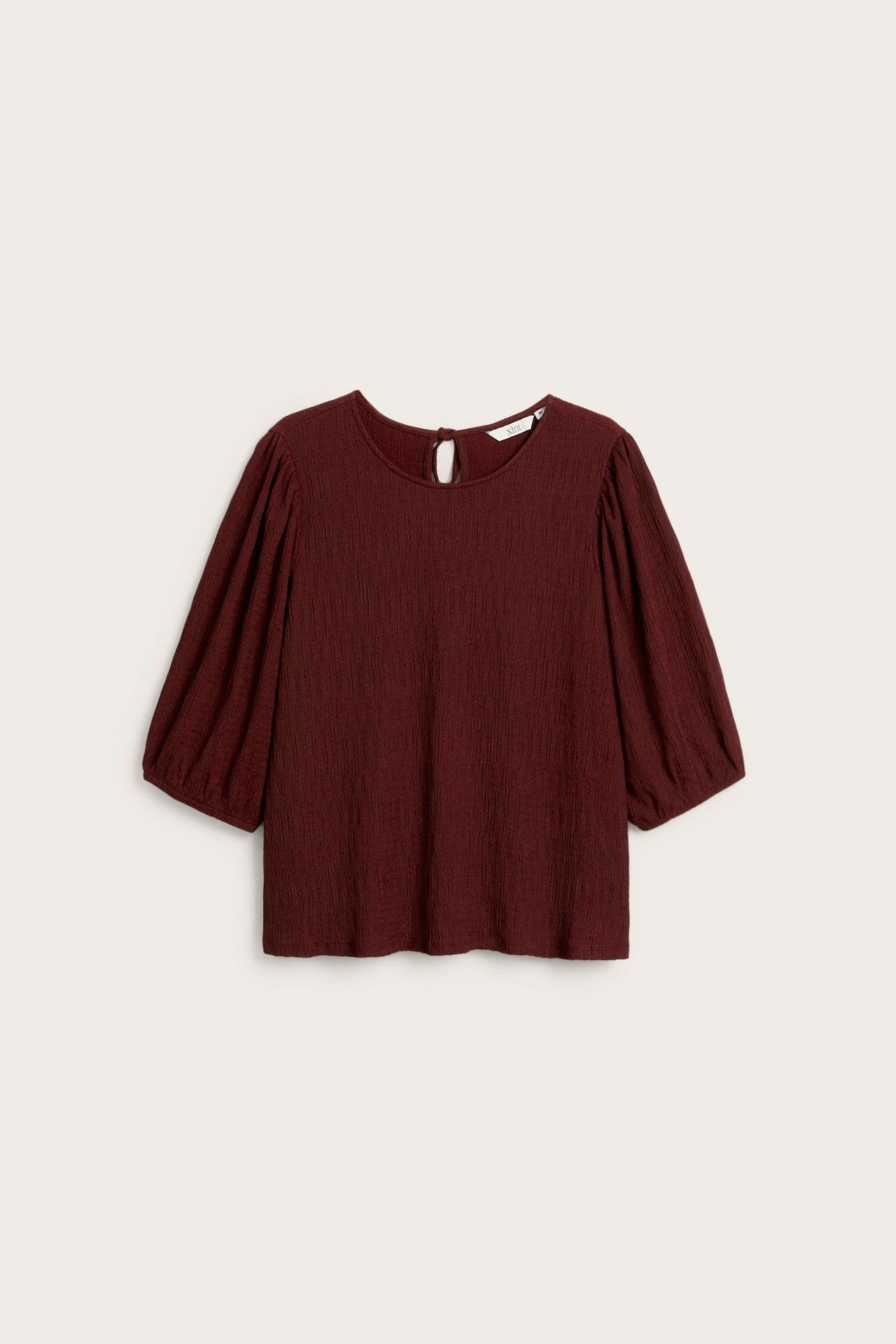 Widok z przodu ciemnoczerwonego, teksturowanego topu z okrągłym dekoltem i bufiastymi rękawami, z wycięciem na plecach.