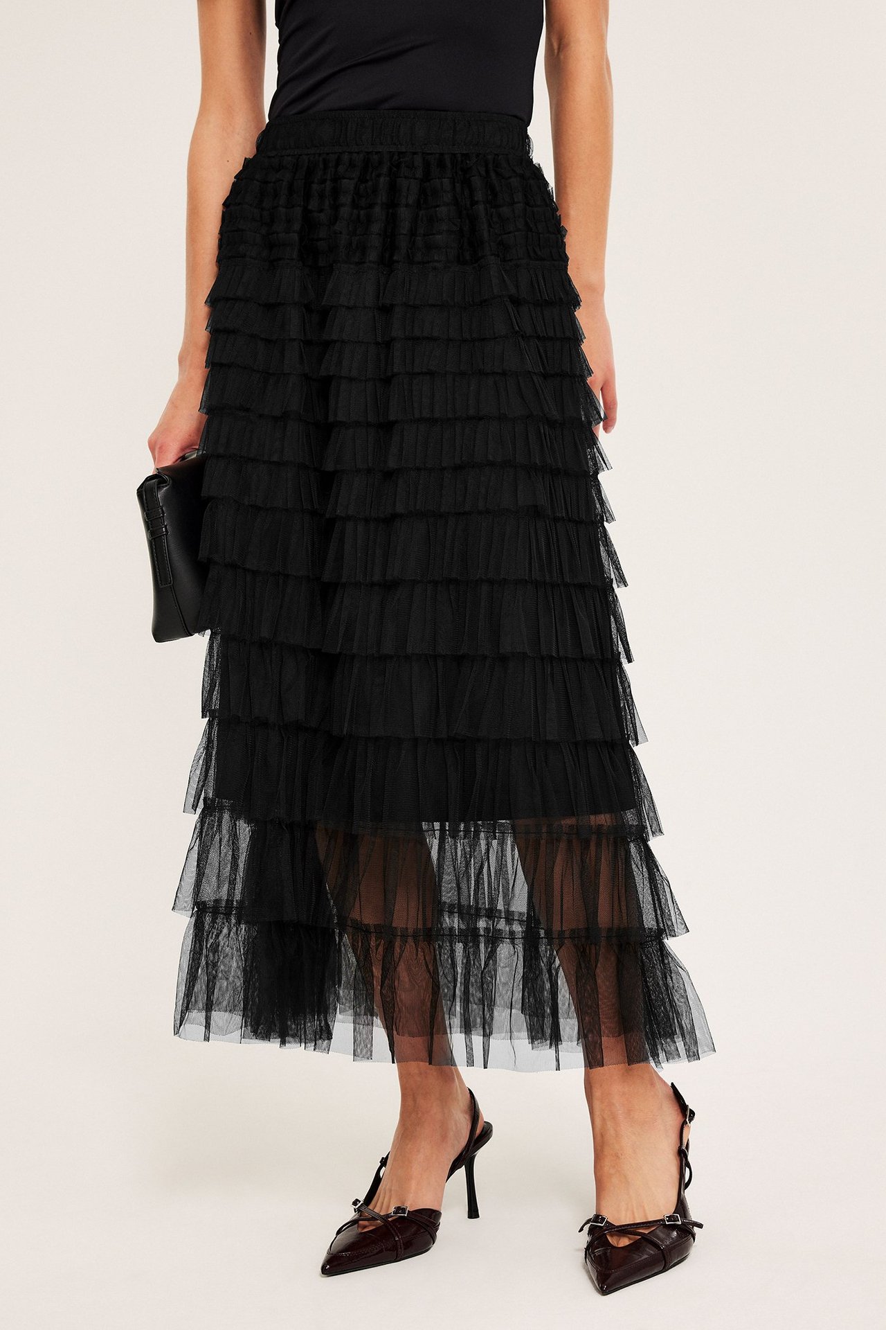 Długa czarna spódnica z tiulu, falbany, wciągany pas, na kobiecie, front.