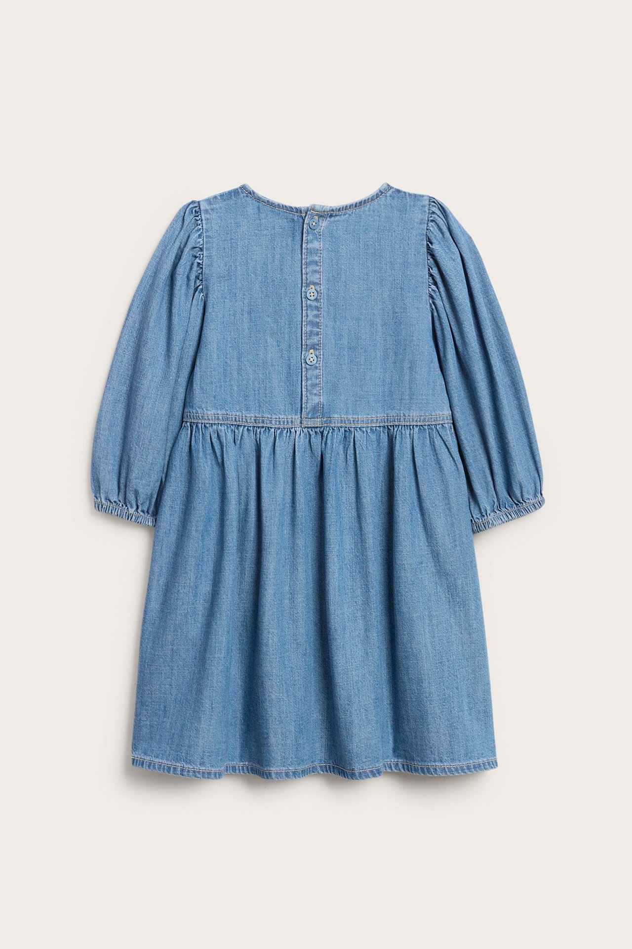 Widok z tyłu: Dziecięca jasnoniebieska sukienka jeansowa z bufiastymi rękawami i zapięciem na guziki.