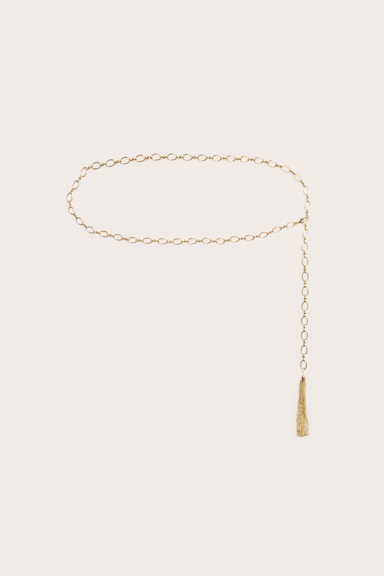 Frontvy av guldfärgat metallkedjebälte med ovala länkar och tofs, även användbart som halsband.