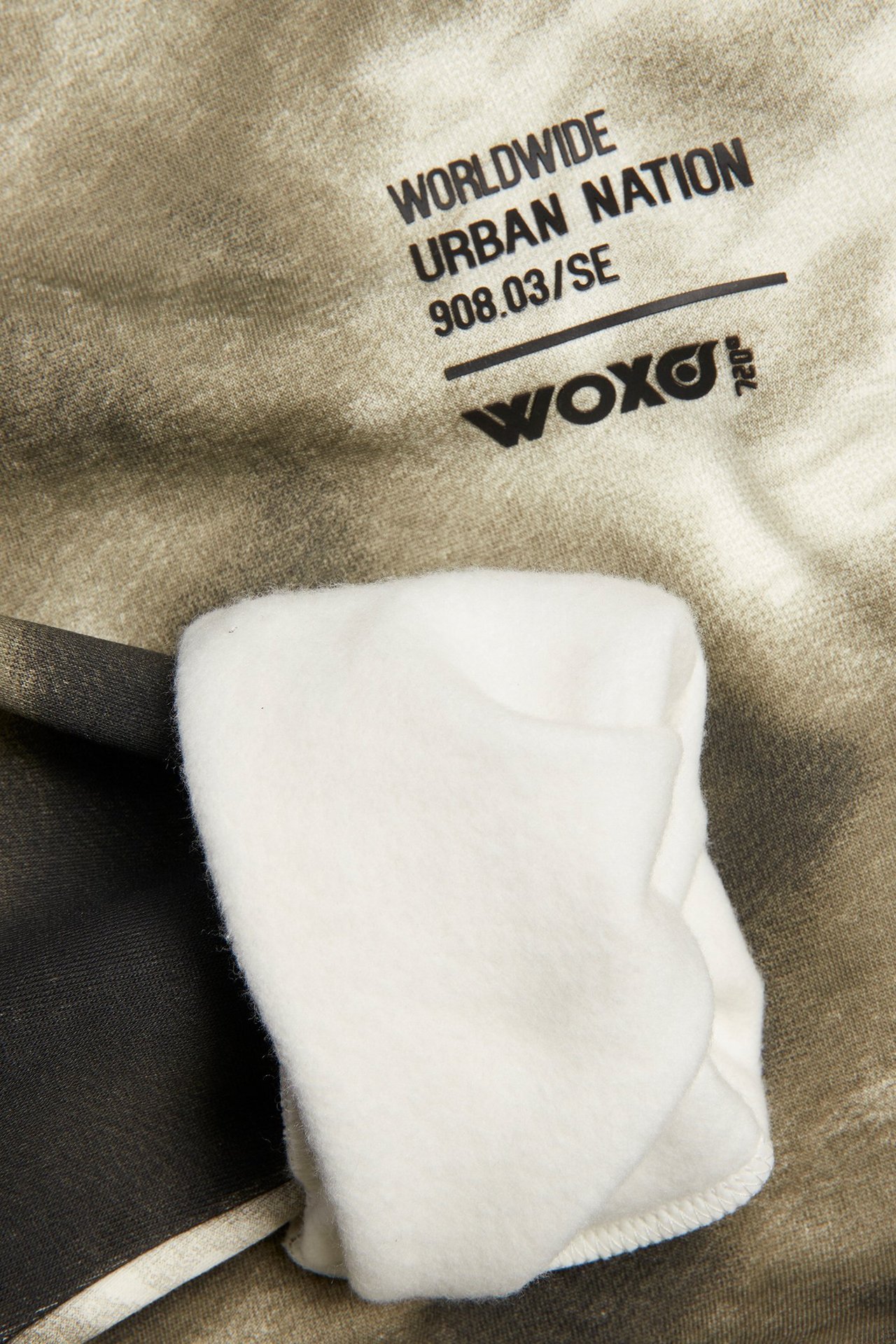 Zbliżenie na zieloną, wzorzystą bluzę dziecięcą z czarnym nadrukiem i miękką, kremową podszewką z polaru.