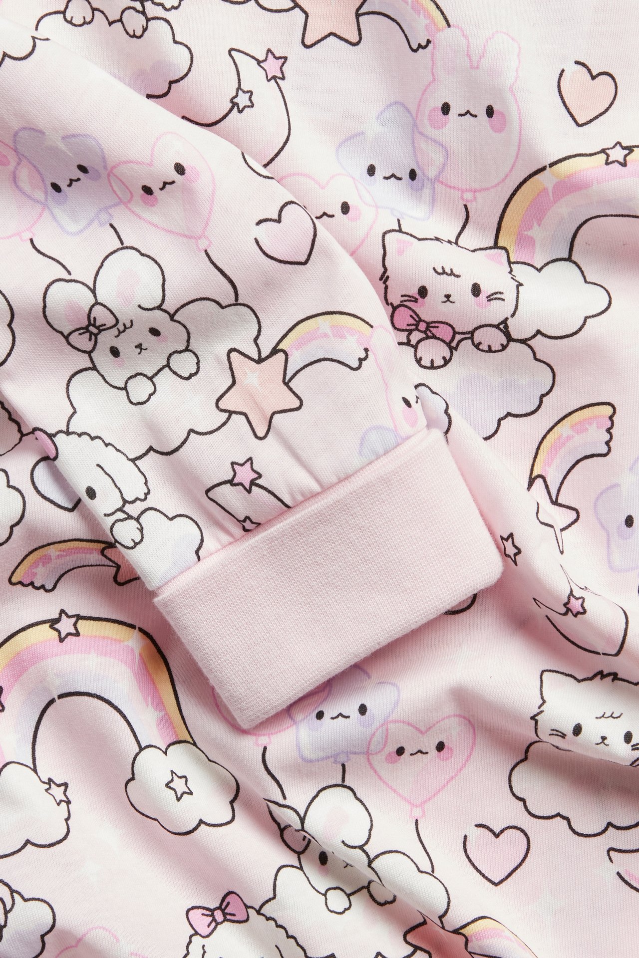 Nærbilde: Barne-nattkjole i lys rosa bomull med lange ermer, dyreprint og brettbare mansjetter.