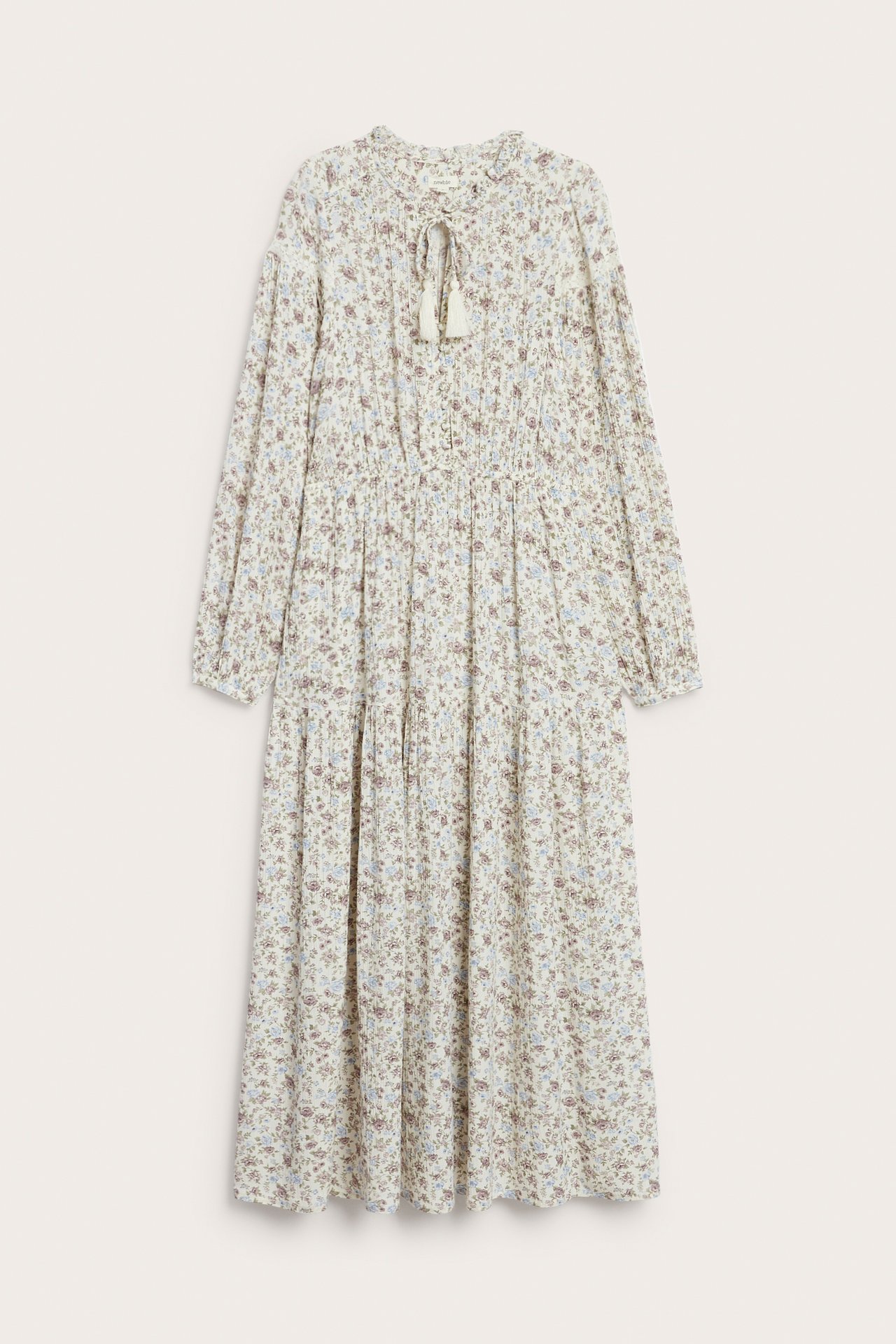 Edestä: Luonnonvalkoinen kukkakuvioinen viskoosimekko, jossa röyhelökaulus, naru, resori vyötäröllä, pussihihat.