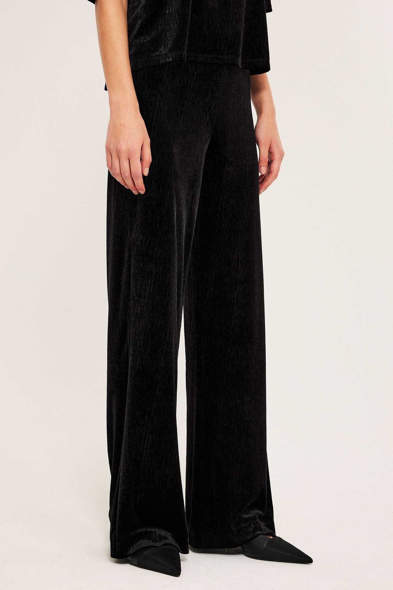 Svart velourbukse med vide ben, jersey, elastan og polyester, vanlig passform.