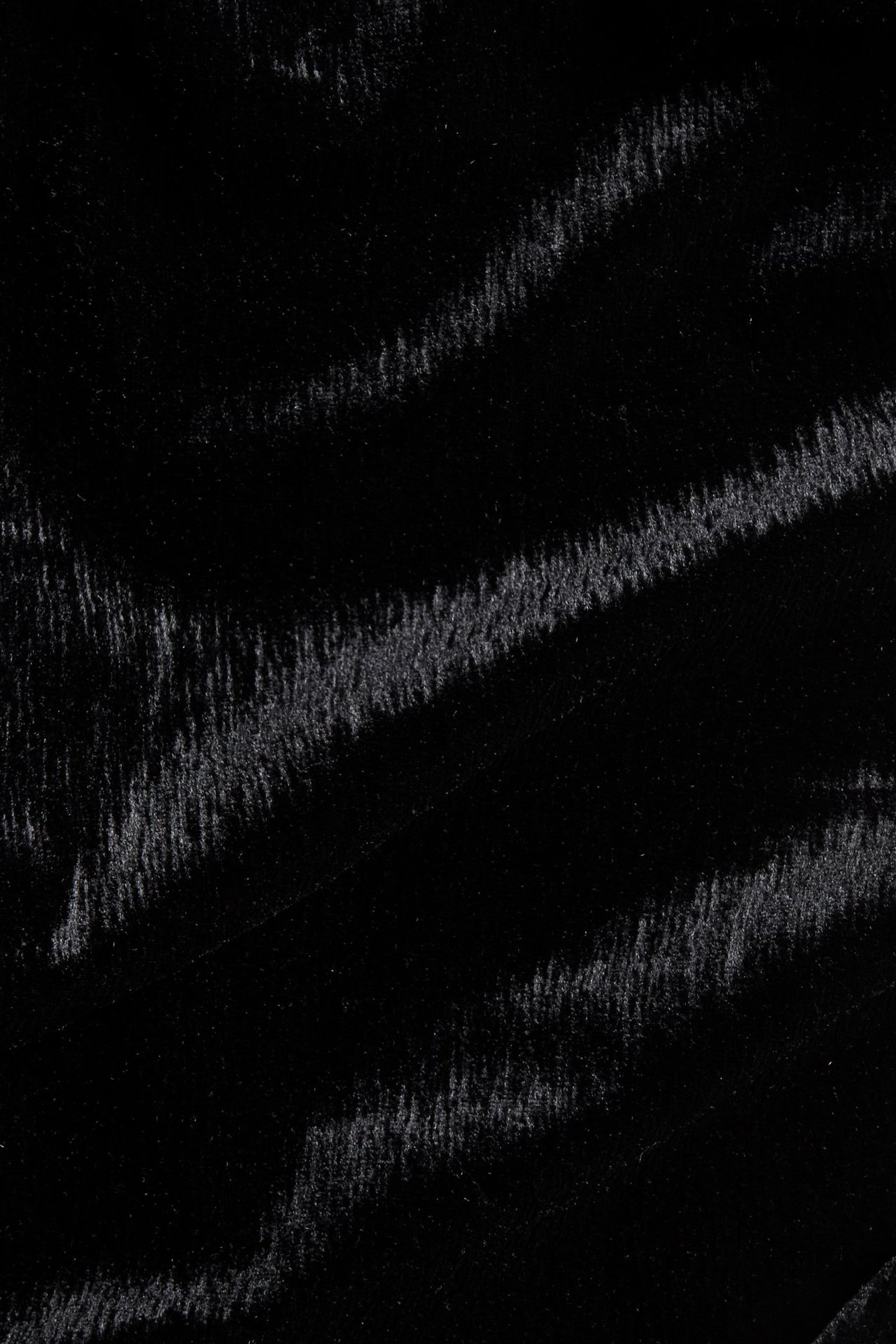 Zbliżenie na czarną strukturalną dzianinę welurową z subtelną fakturą.