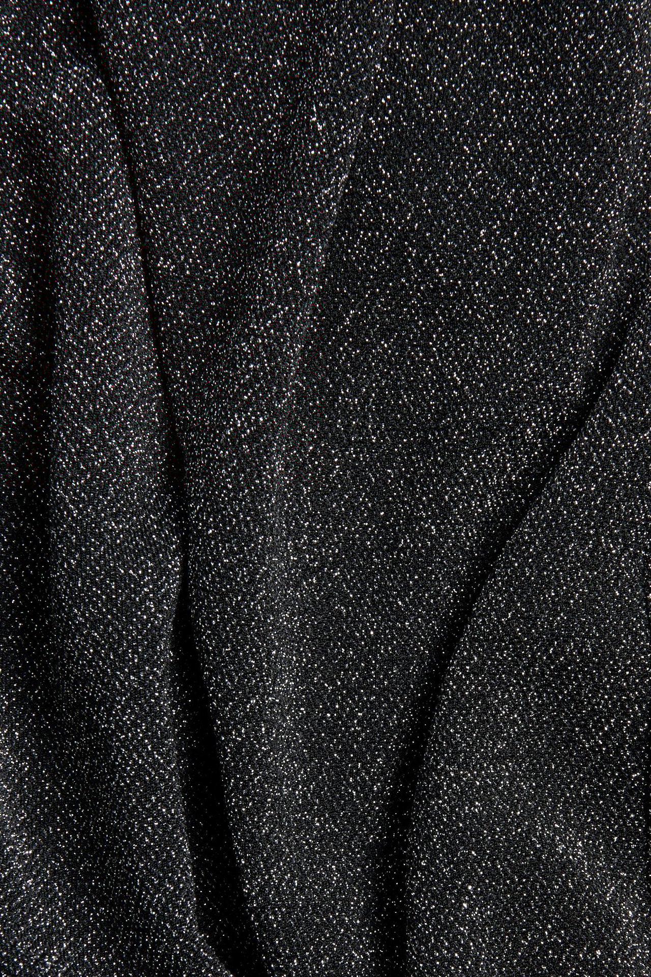 Zbliżenie czarnego, błyszczącego dzianinowego materiału na spodnie.