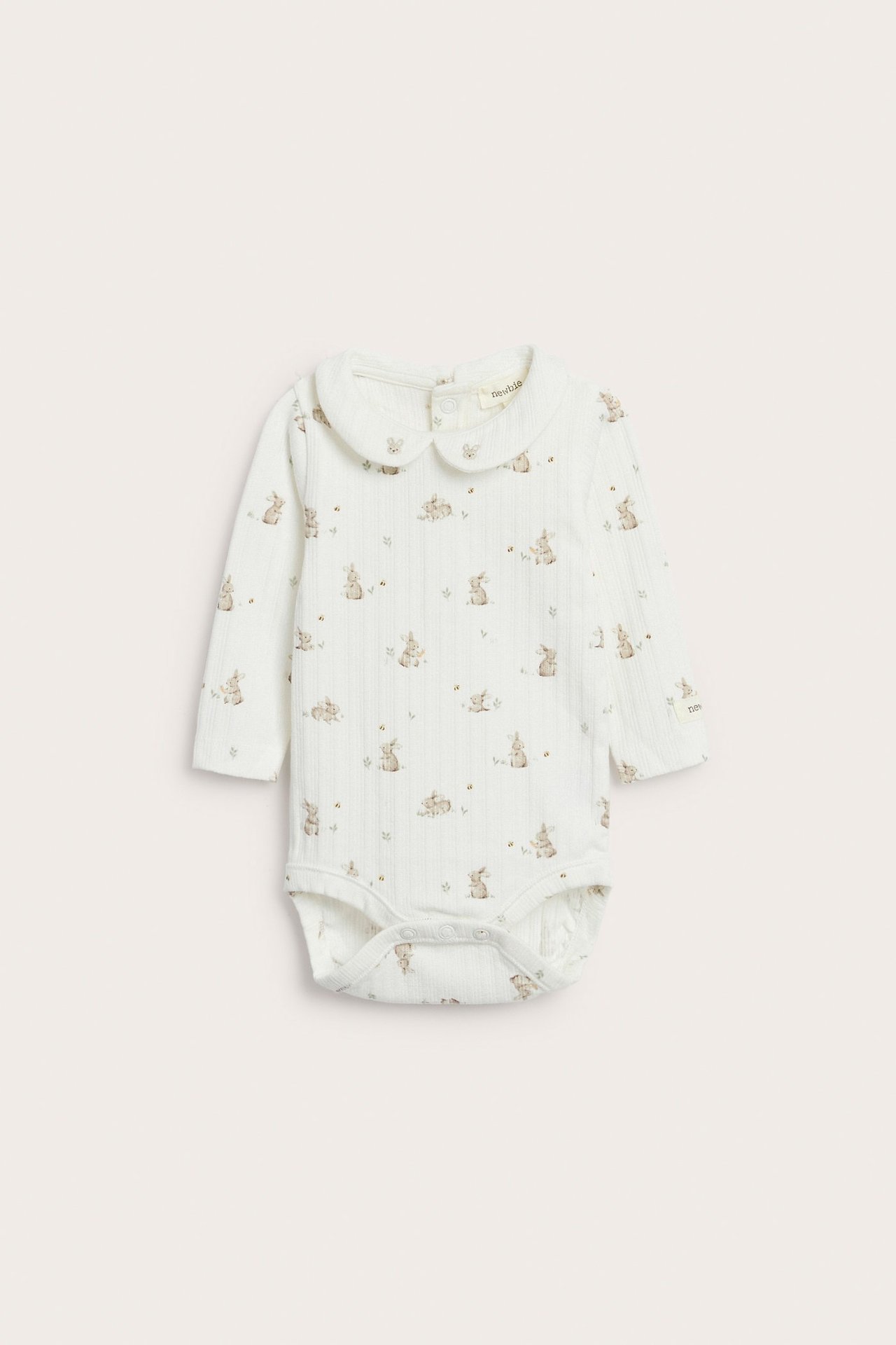 Offwhite ribbet babybody, forfra, med Peter Pan-krage, kanintrykk og trykknapper.