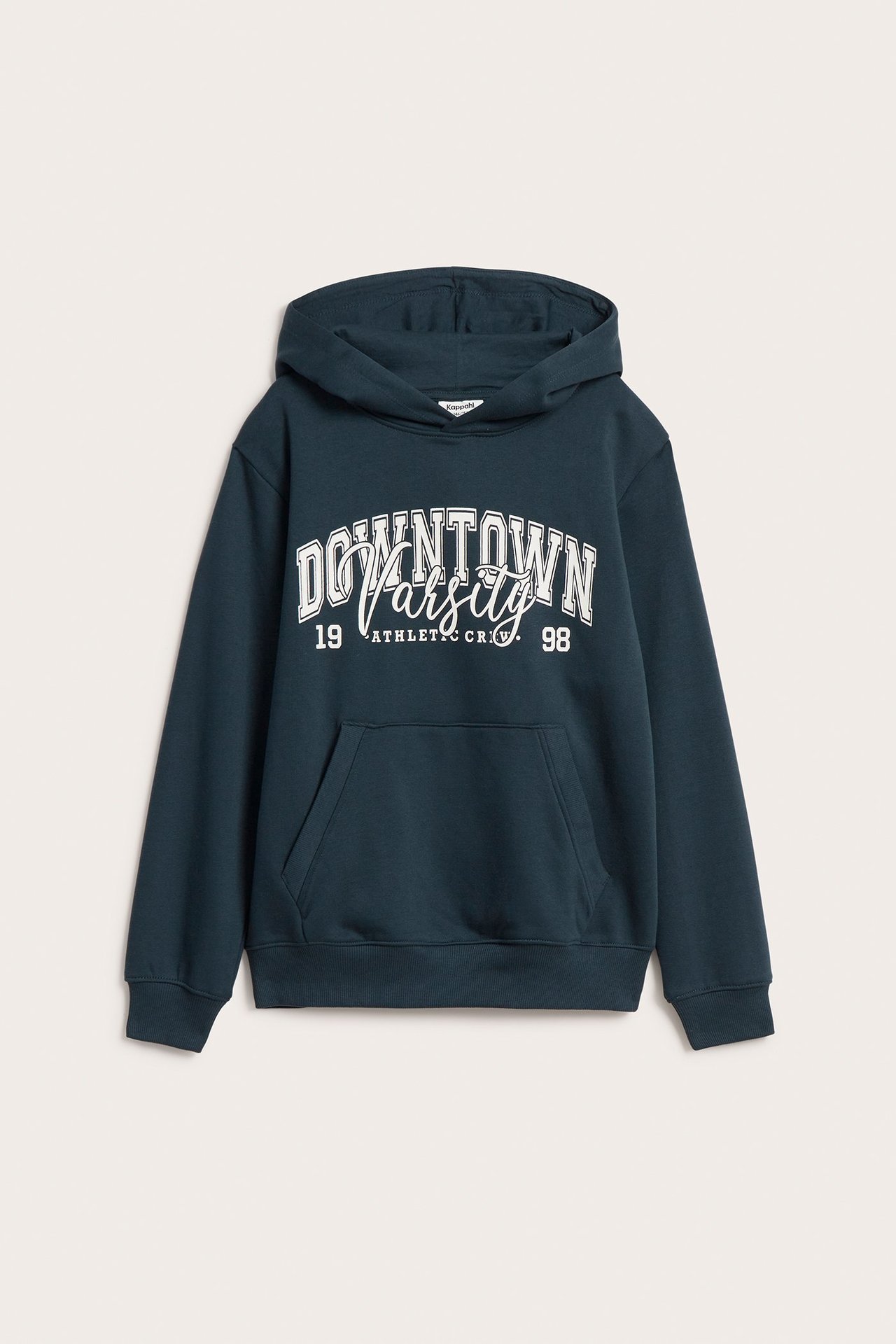 Edestä lasten sininen huppari, jossa valkoinen "DOWNTOWN VARSITY" -painatus ja kengurutasku.