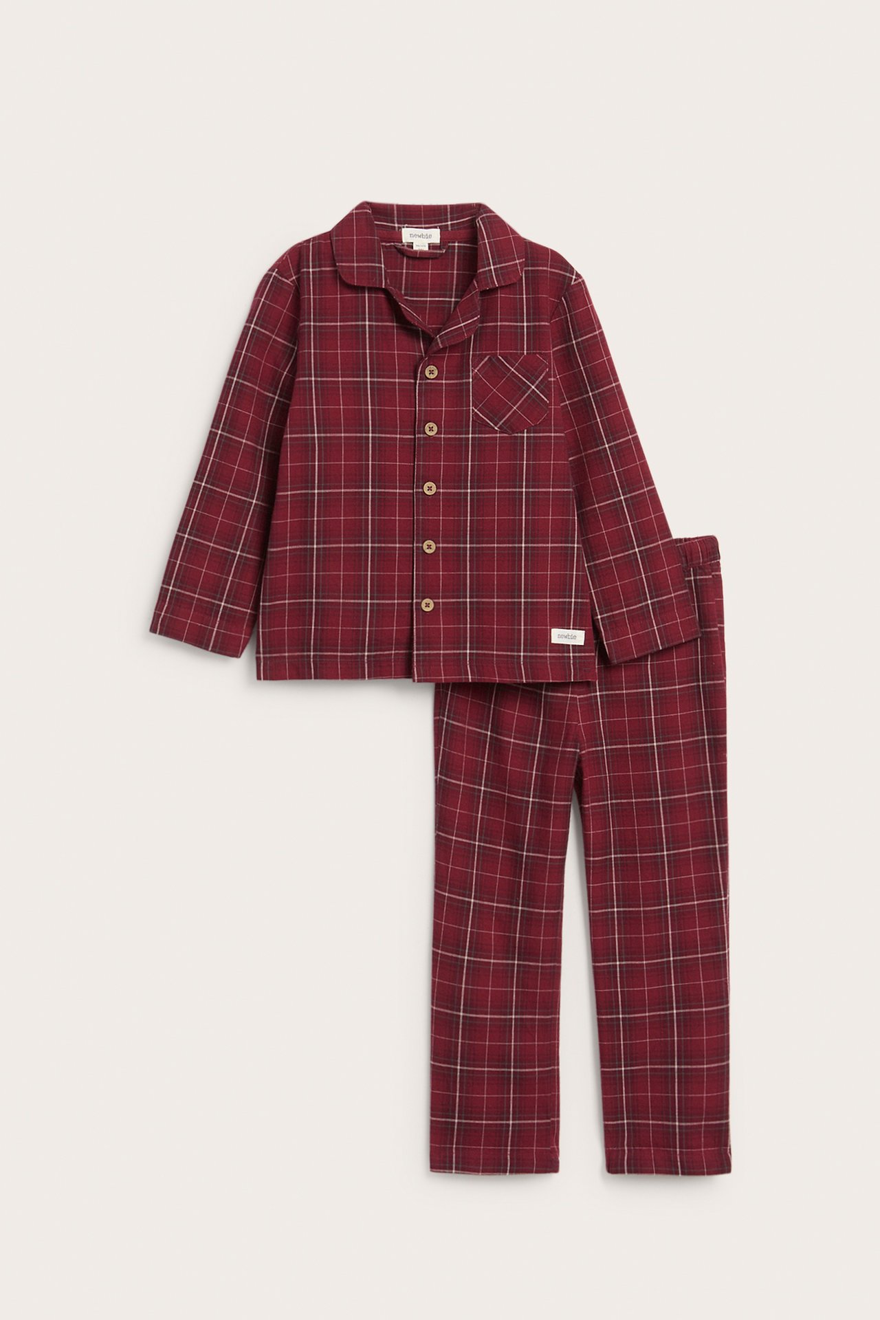 Frontvy av en rödrutig flanellpyjamas med krage, knäppning fram och långbyxor.