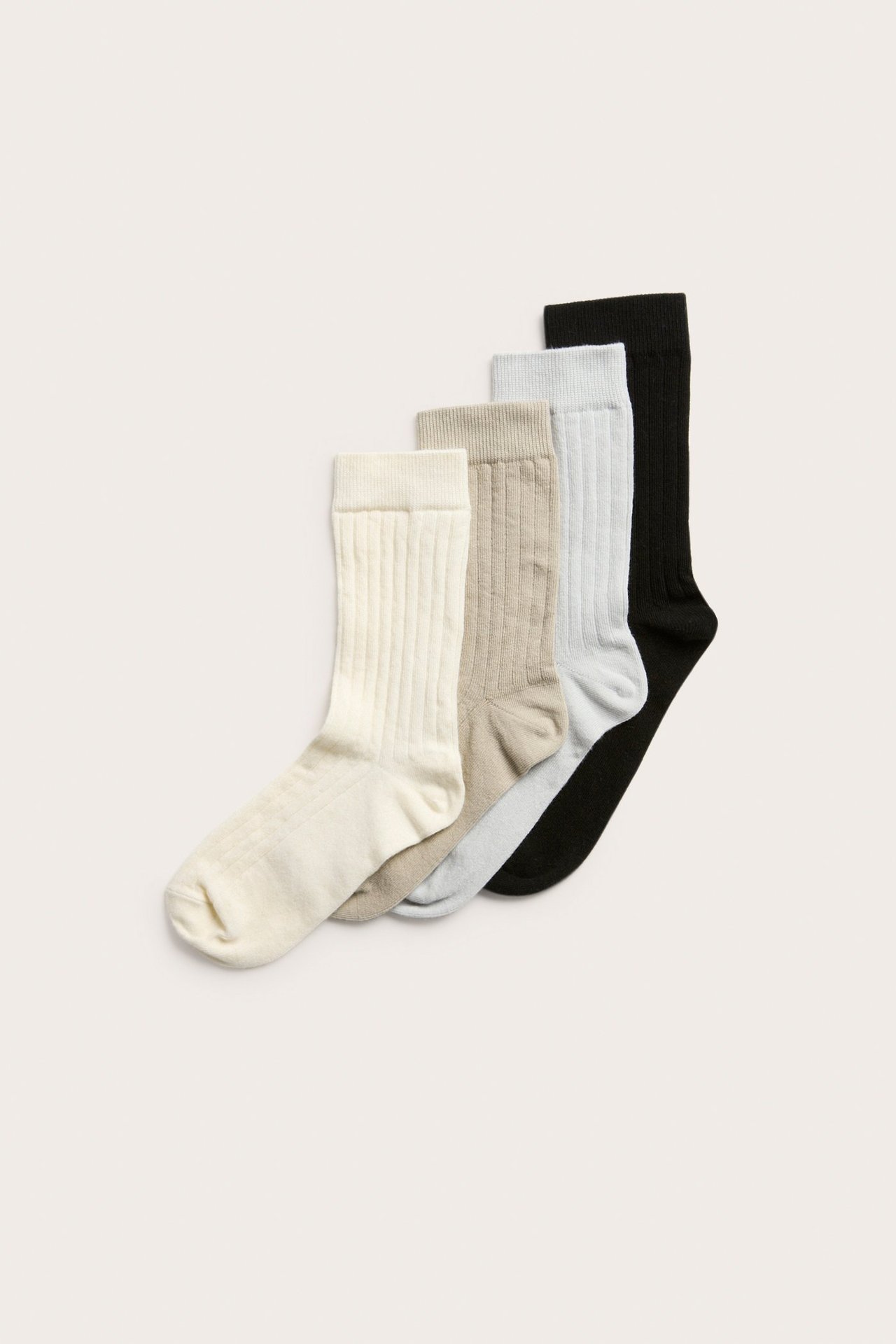 Widok z góry na cztery pary prążkowanych skarpet: ecru, jasnobrązowe, jasnoniebieskie i czarne.