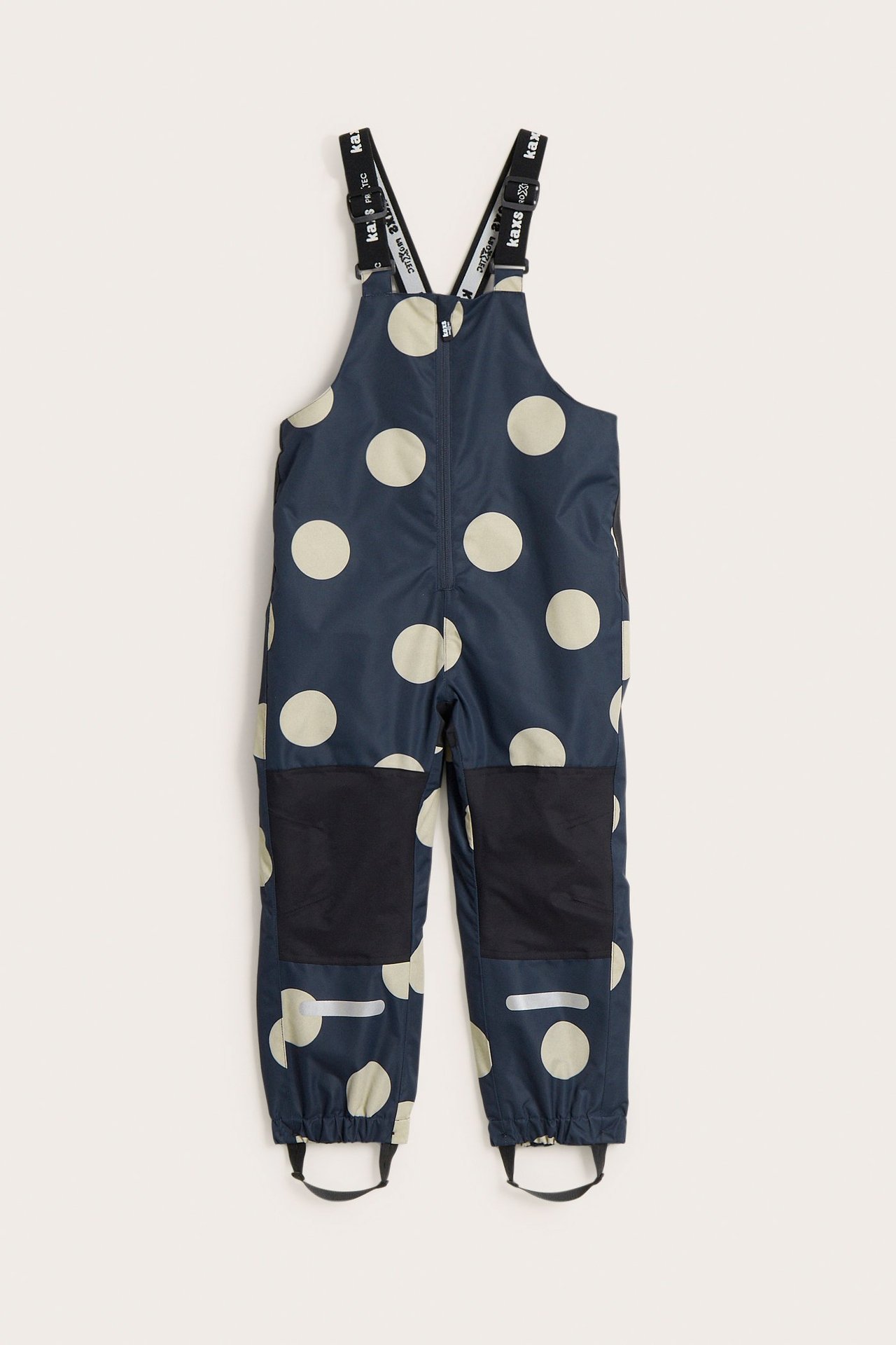 Edestäpäin: tummansiniset pilkulliset lasten kuorihousut mustilla olkaimilla ja polvivahvikkeilla.