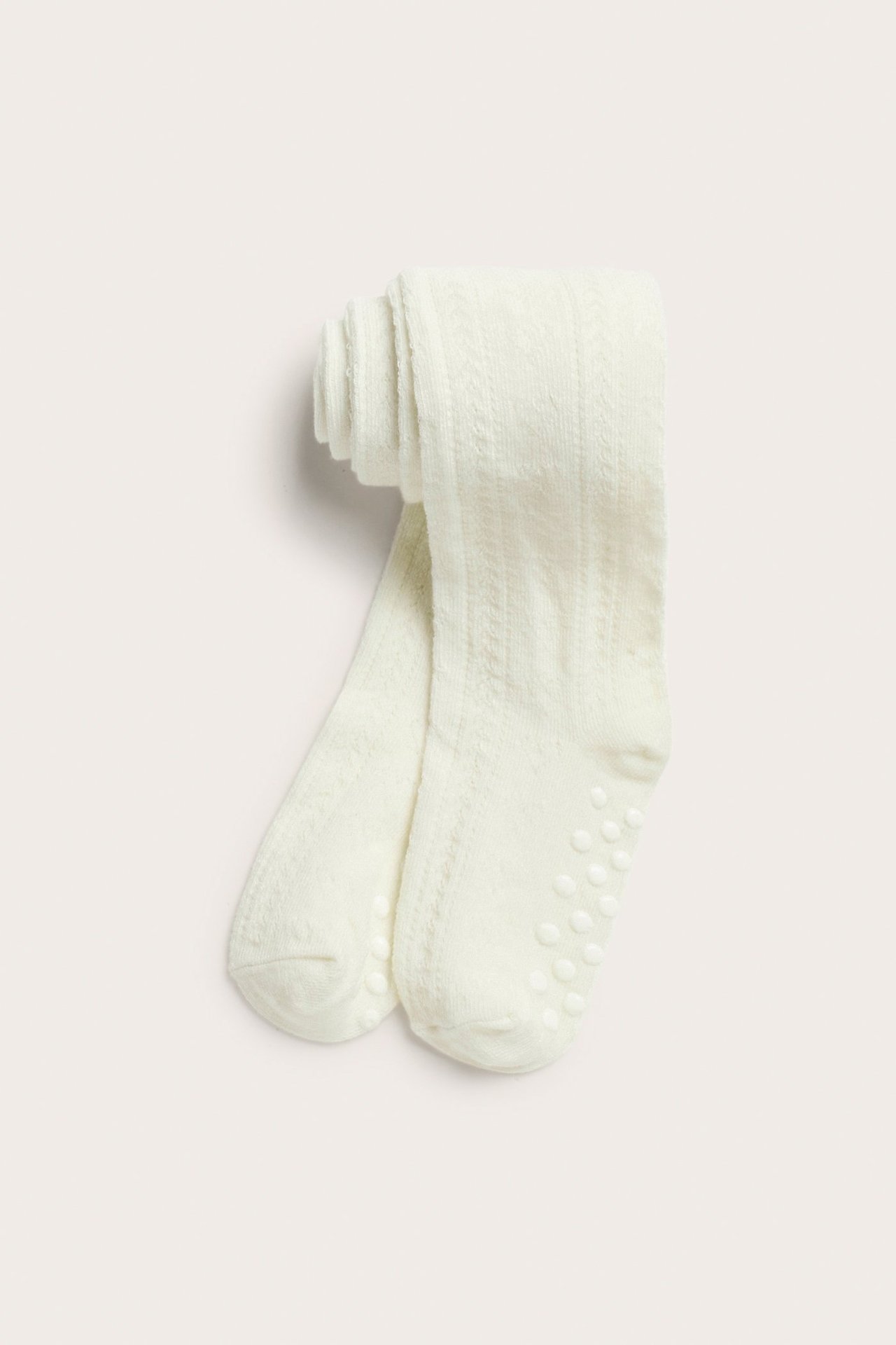 Ovenfra: Offwhite mønstrede babystrømpebukser med antiskli-såler.