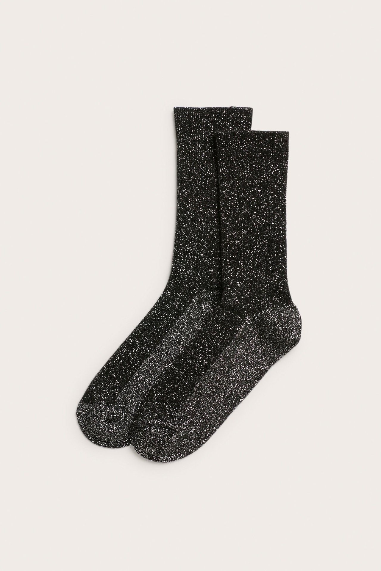 Widok z przodu pary czarnych skarpetek z brokatem i prążkowanymi ściągaczami, leżących płasko.